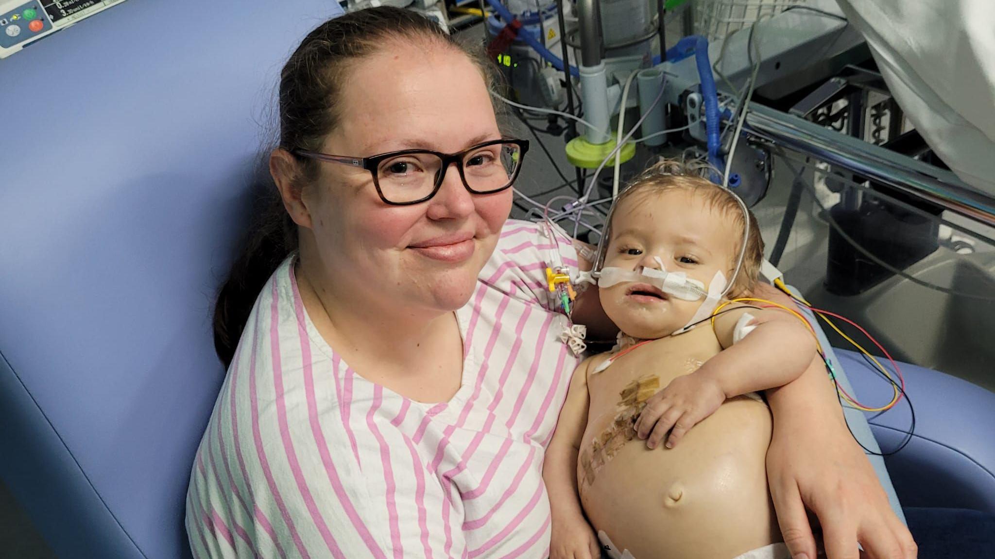 A mother and a baby in hospital with tubes attached