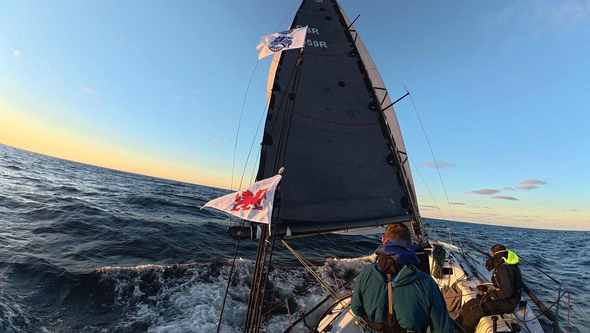 Llun o ddau o'r tim hwylio yn ystod y ras hwylio ar draws yr Iwerydd. 