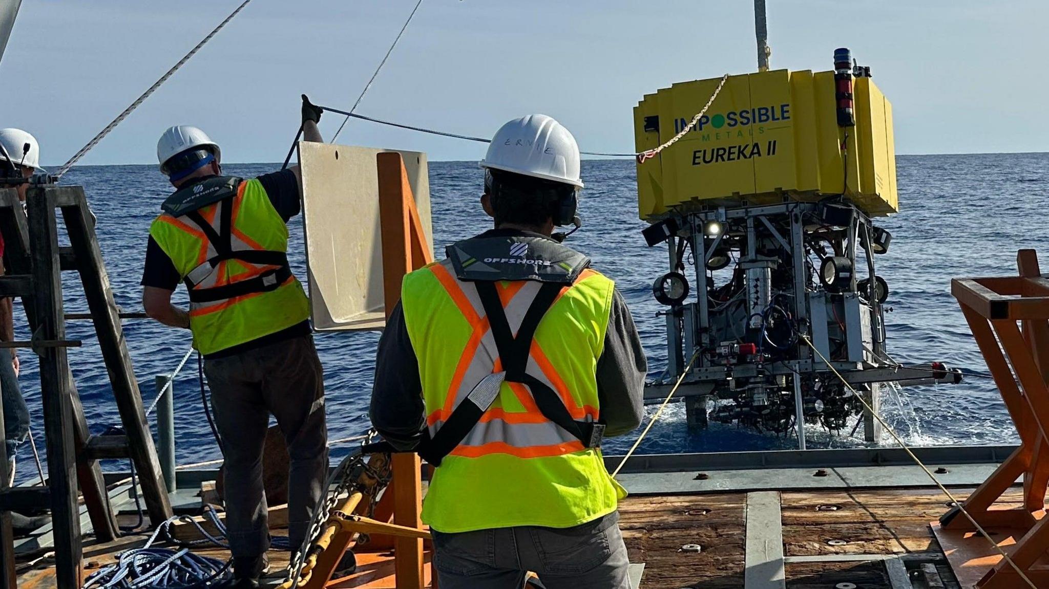 Crew lower a mining machine from Impossible Metals into the sea.