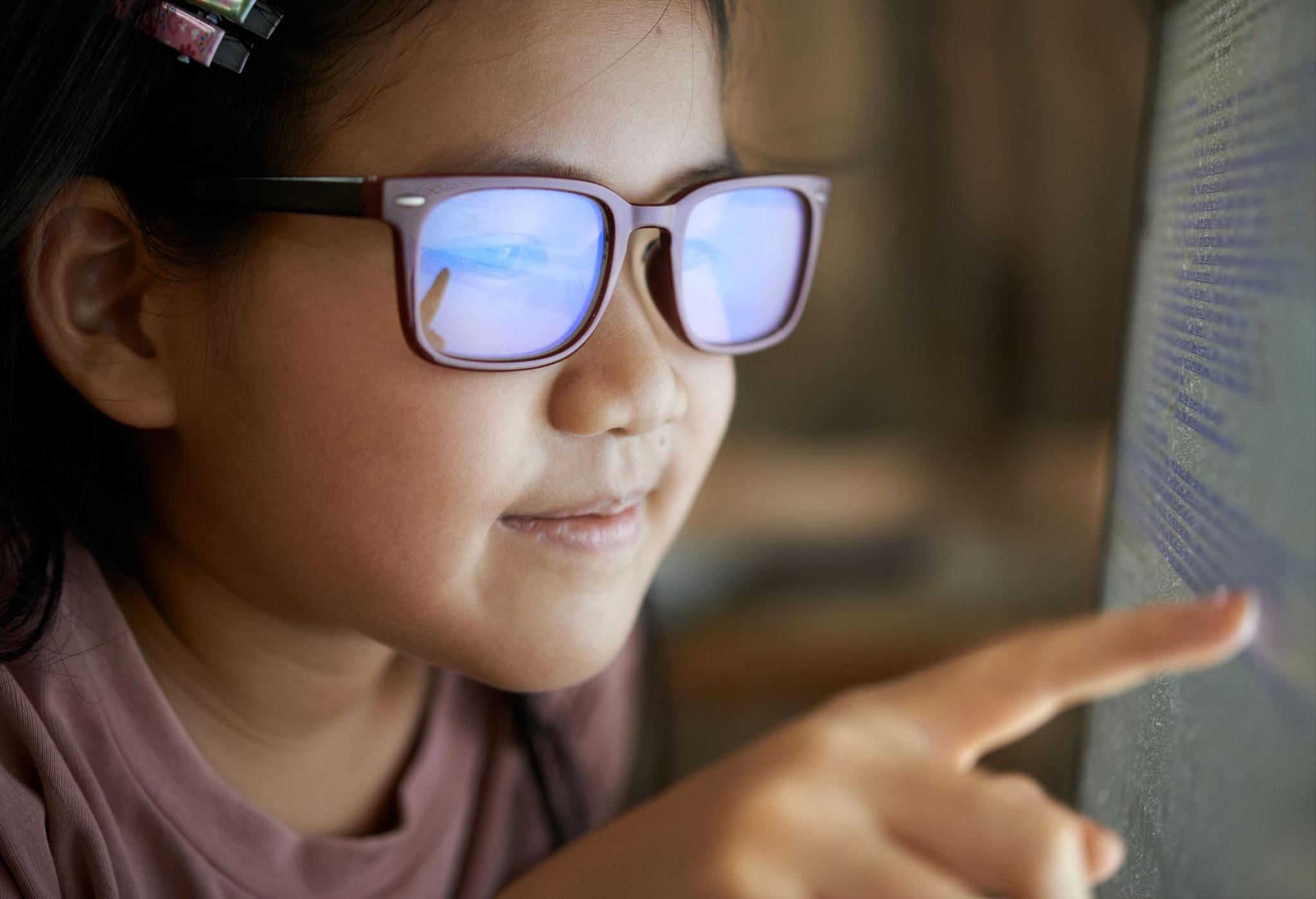 Girls wearing glasses looking at a computer screen