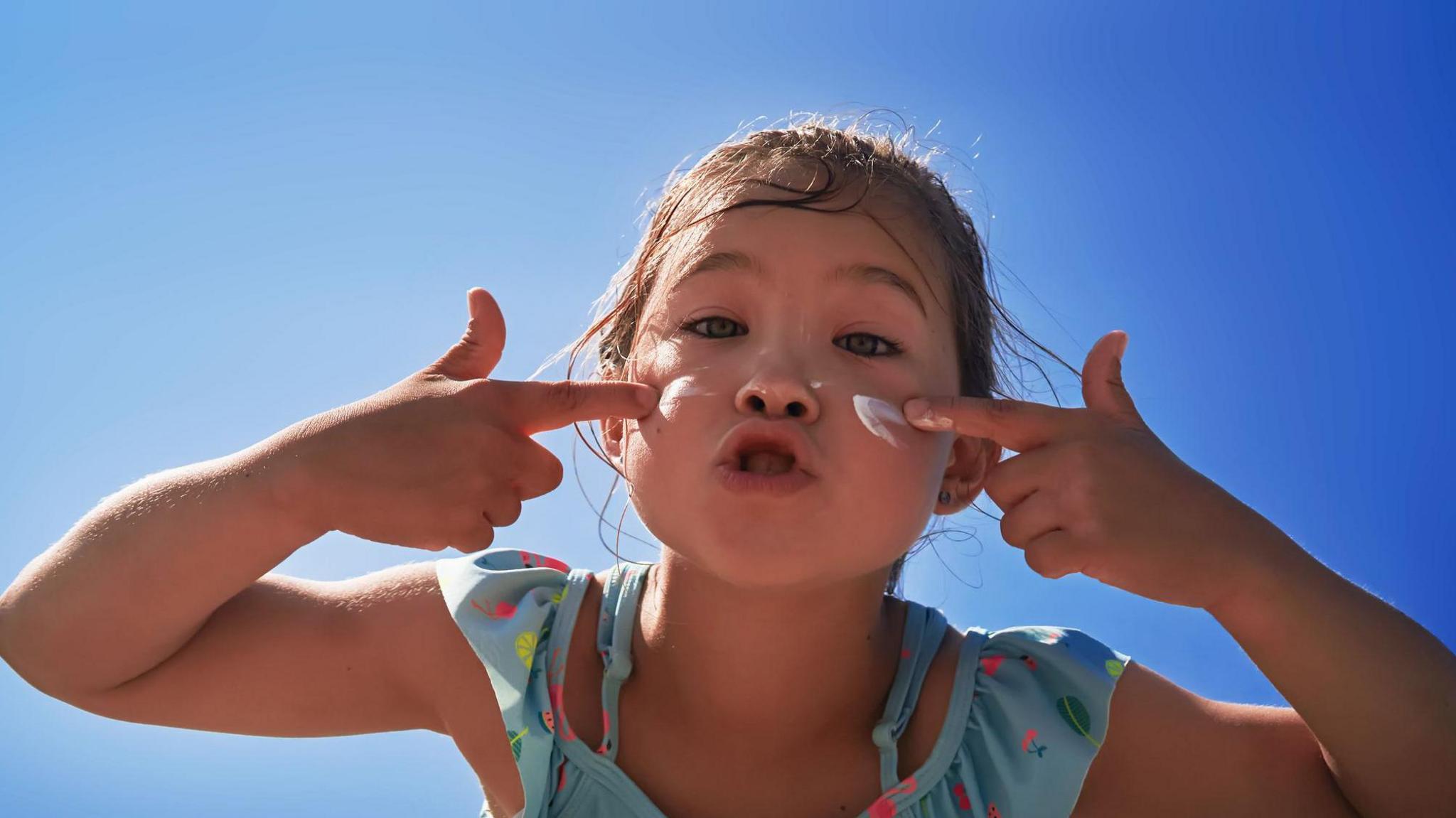 Young girl with a smear of suncream