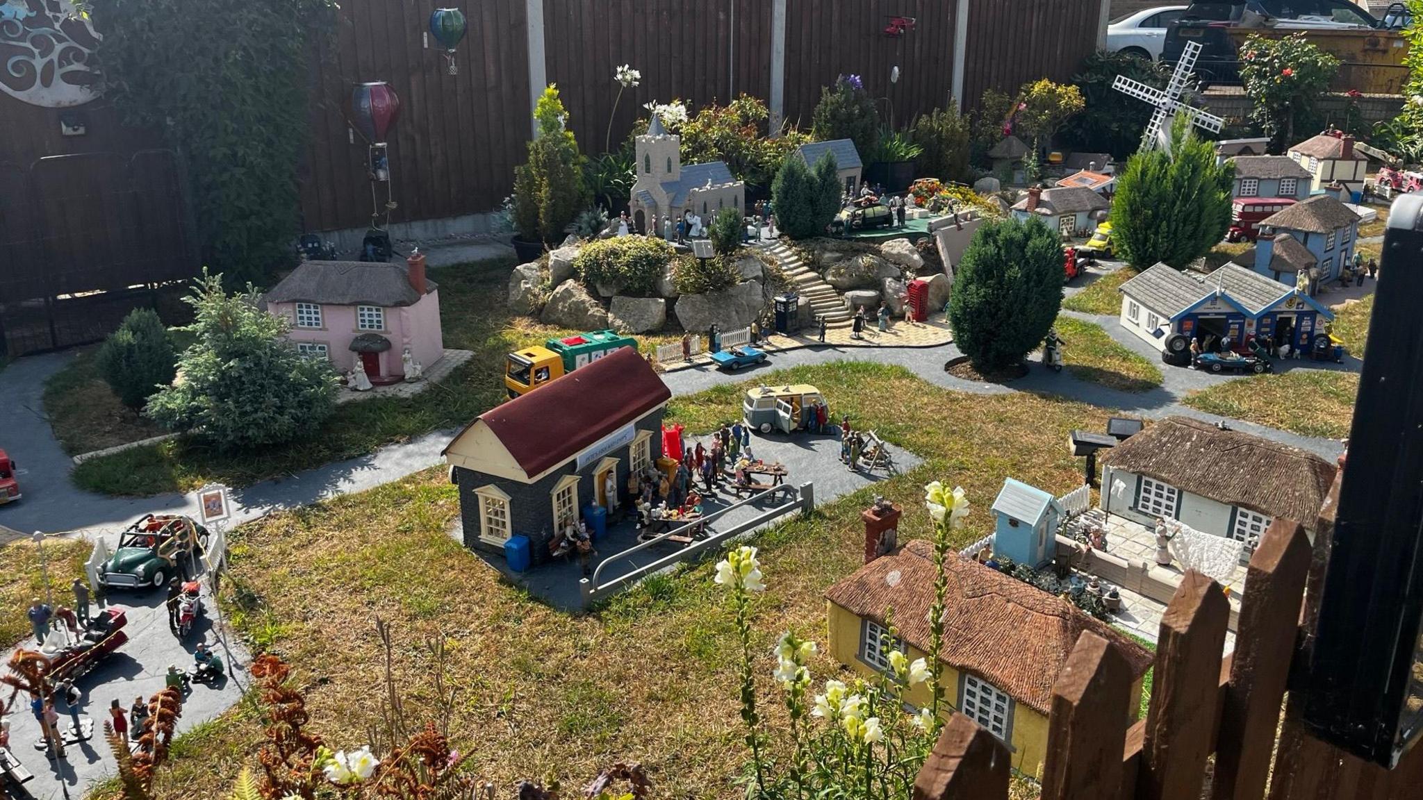 The model village with about 20 tiny properties in Jane High's front garden at her home in Scratby. Within the picture there are many miniature figures that populate the scene.
