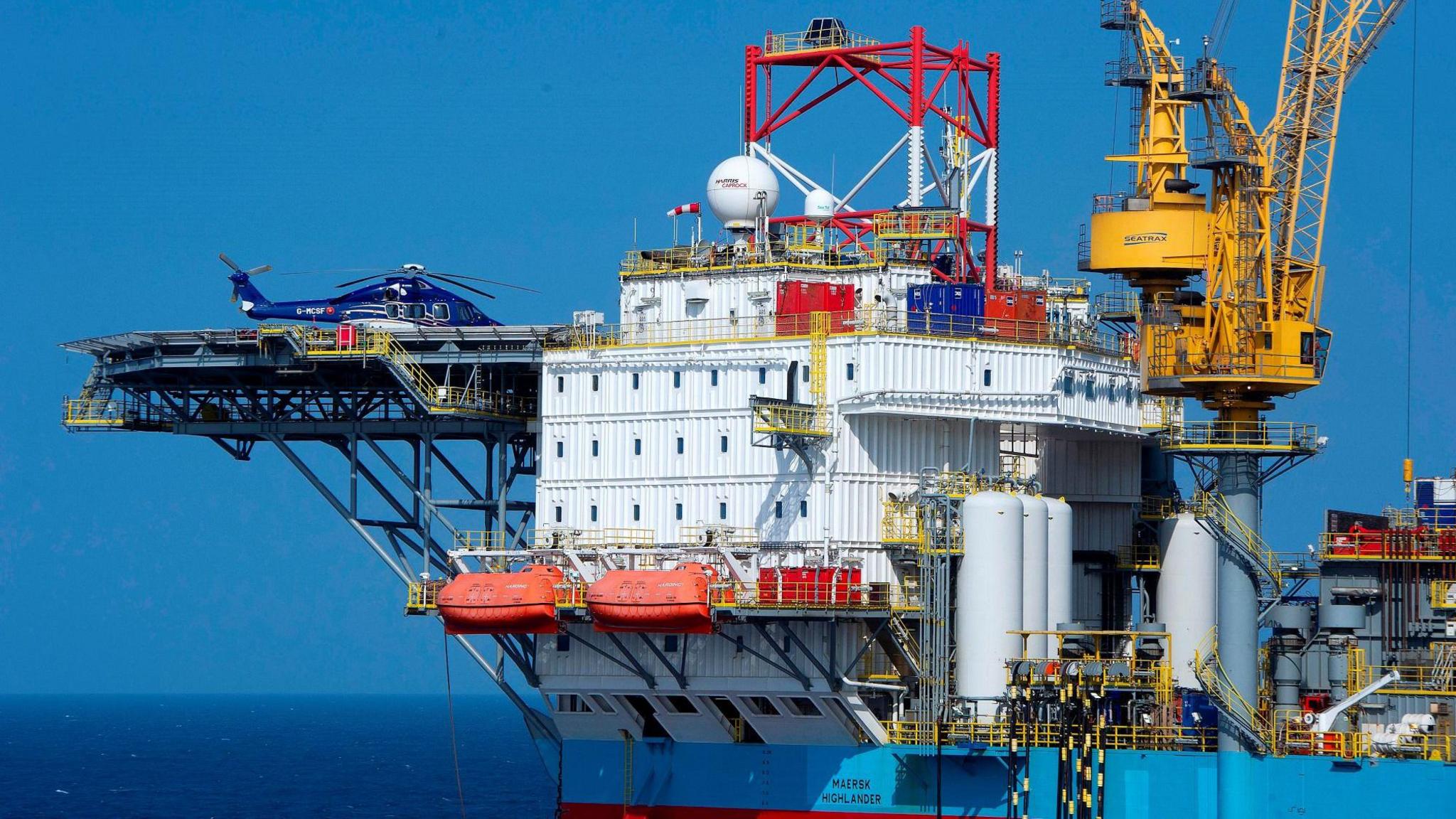 A helicopter sits idle on a helipad attached to the Culzean oil production platform in the North Sea