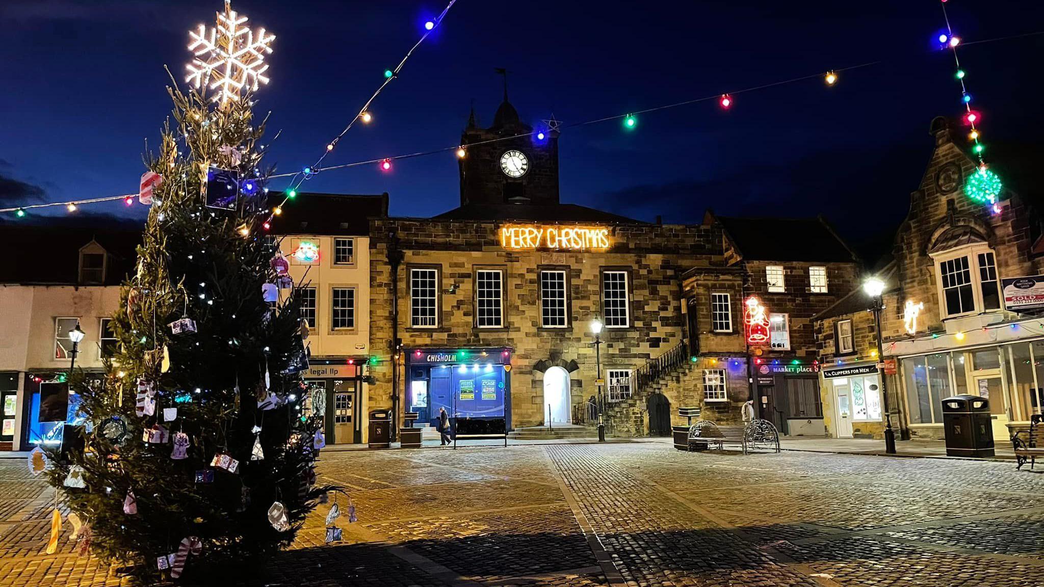 The market square in Alnwick from Christmas 2021 with a larger, decorated Christmas tree in the centre.