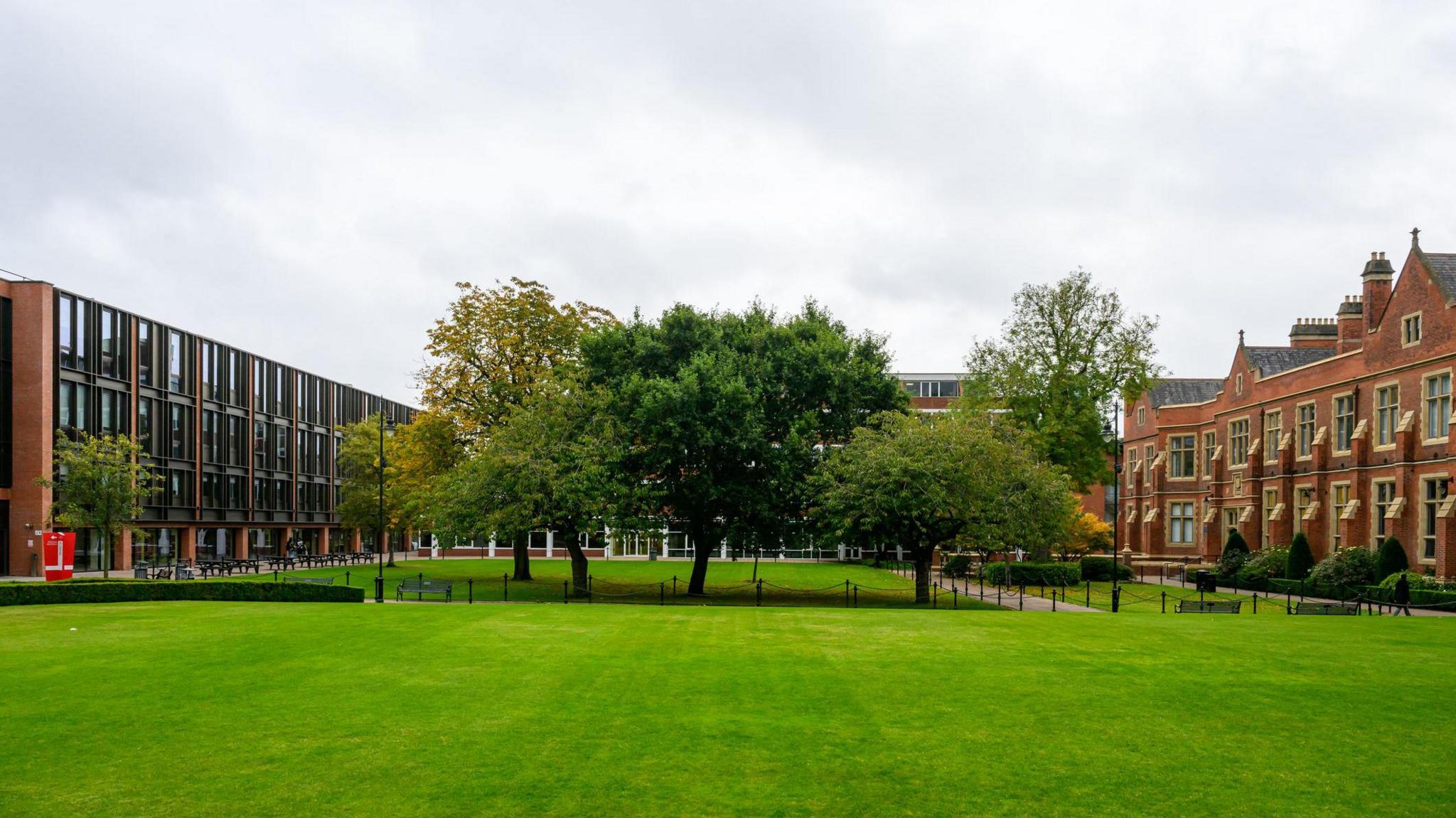 A lawn between campus buildings at Queen's University, Belfast. The building on the left is very modern with red brick and lots of glazing,  The older Lanyon Building on the right is also red brick but it was completed in 1849. 