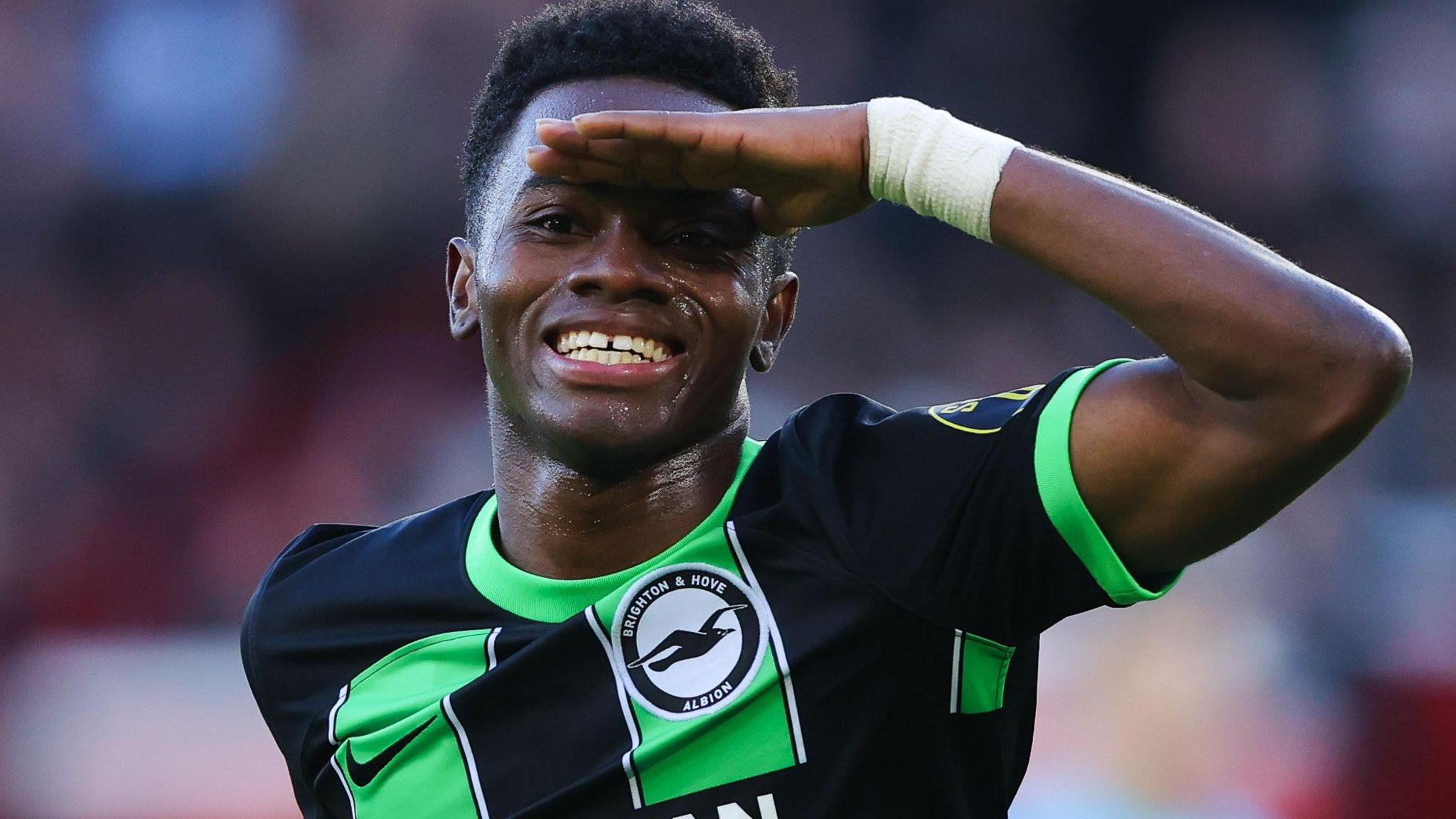 Simon Adingra celebrates scoring for Brighton with a left-armed salute to the camera