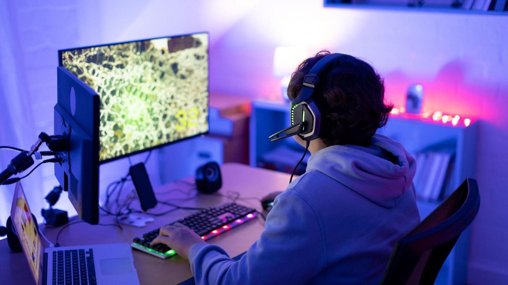 a boy playing a video game wearing a headset.
