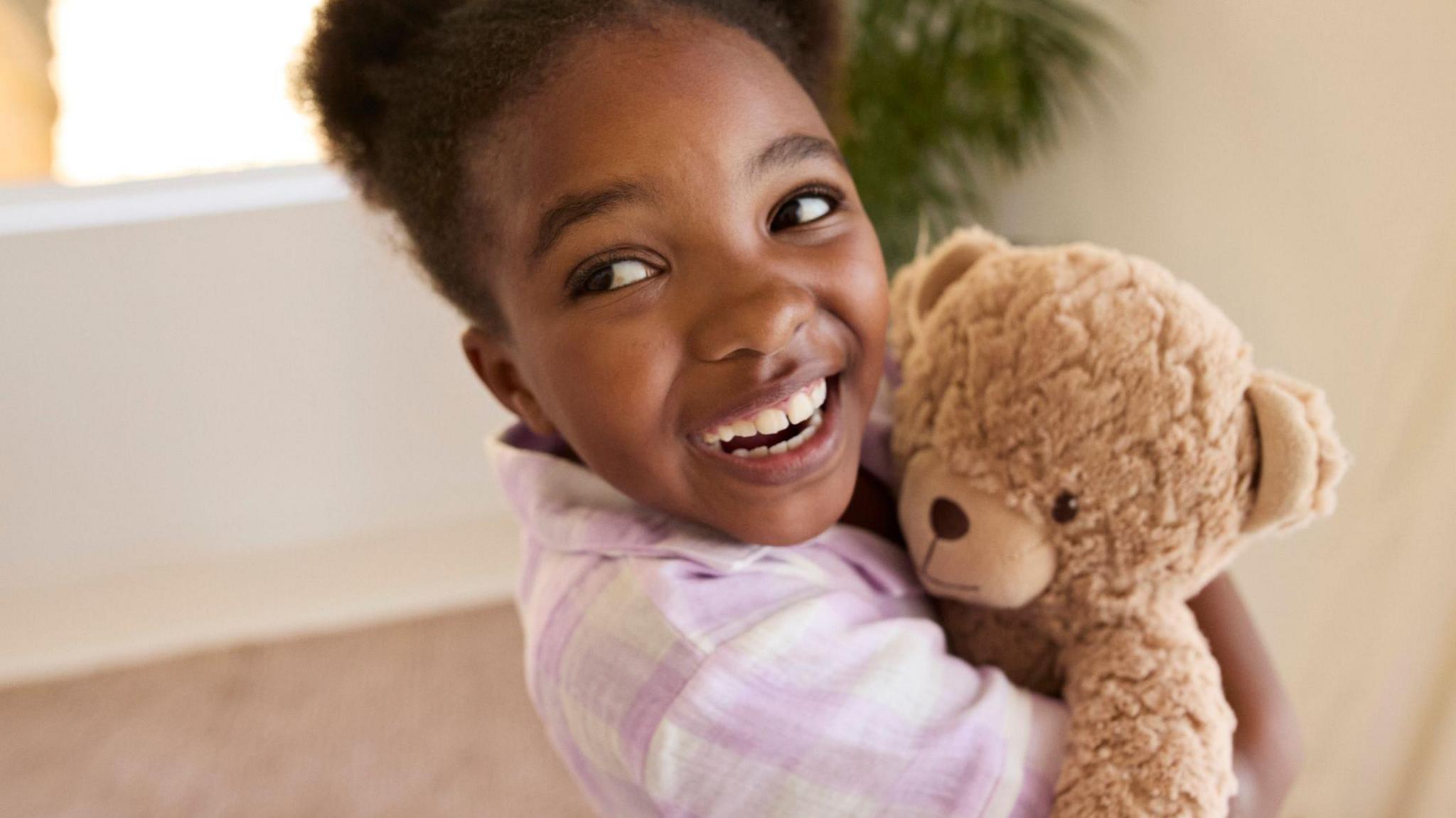 a girl hugging a teddy bear.