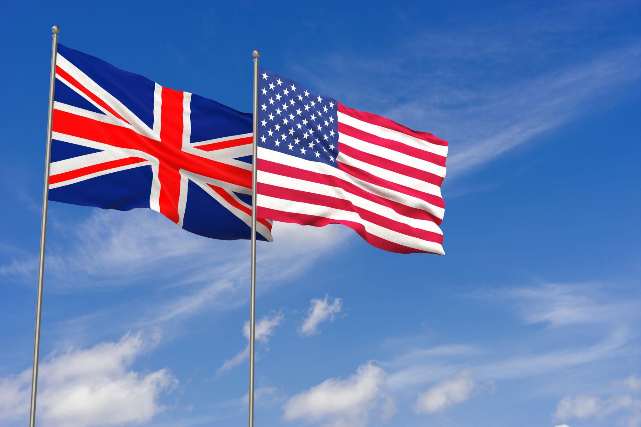 US and UK flags fly against blue sky