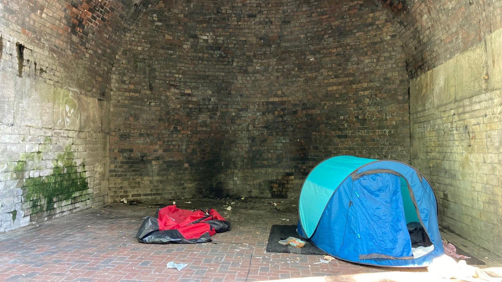 A blue tent inside one of the railway arches