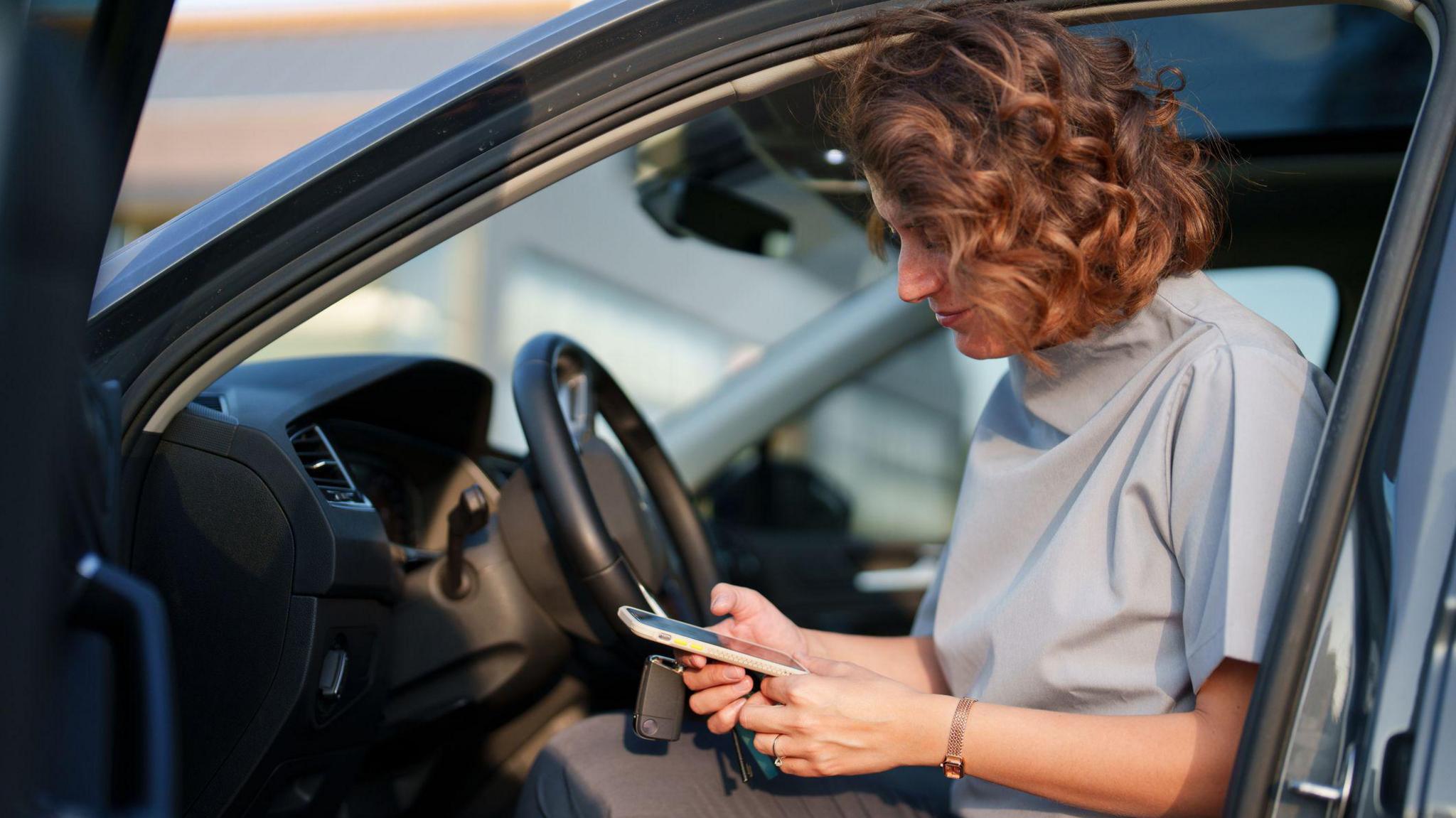 A woman on her phone in a car