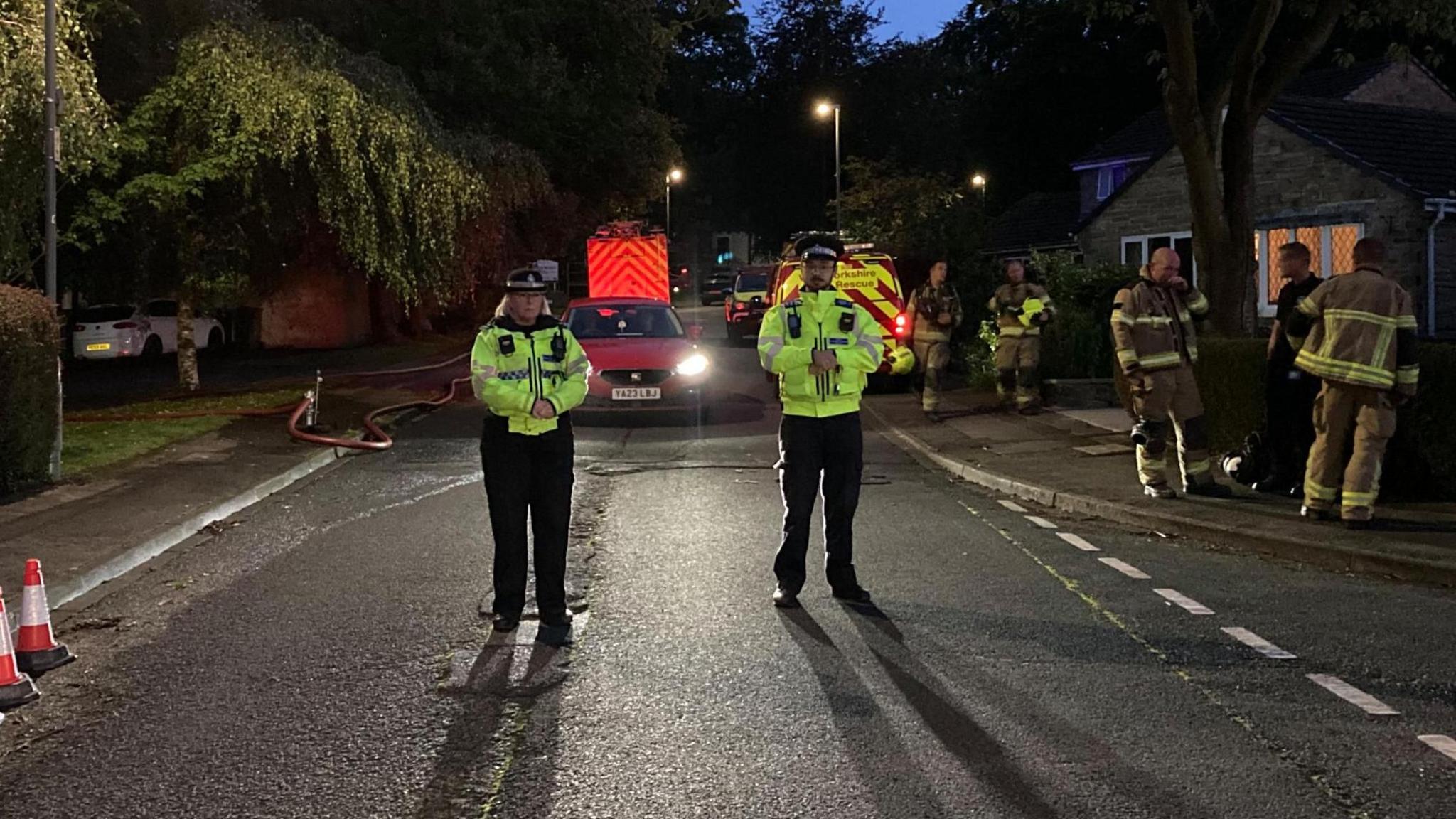 Police officers standing near a fire engine