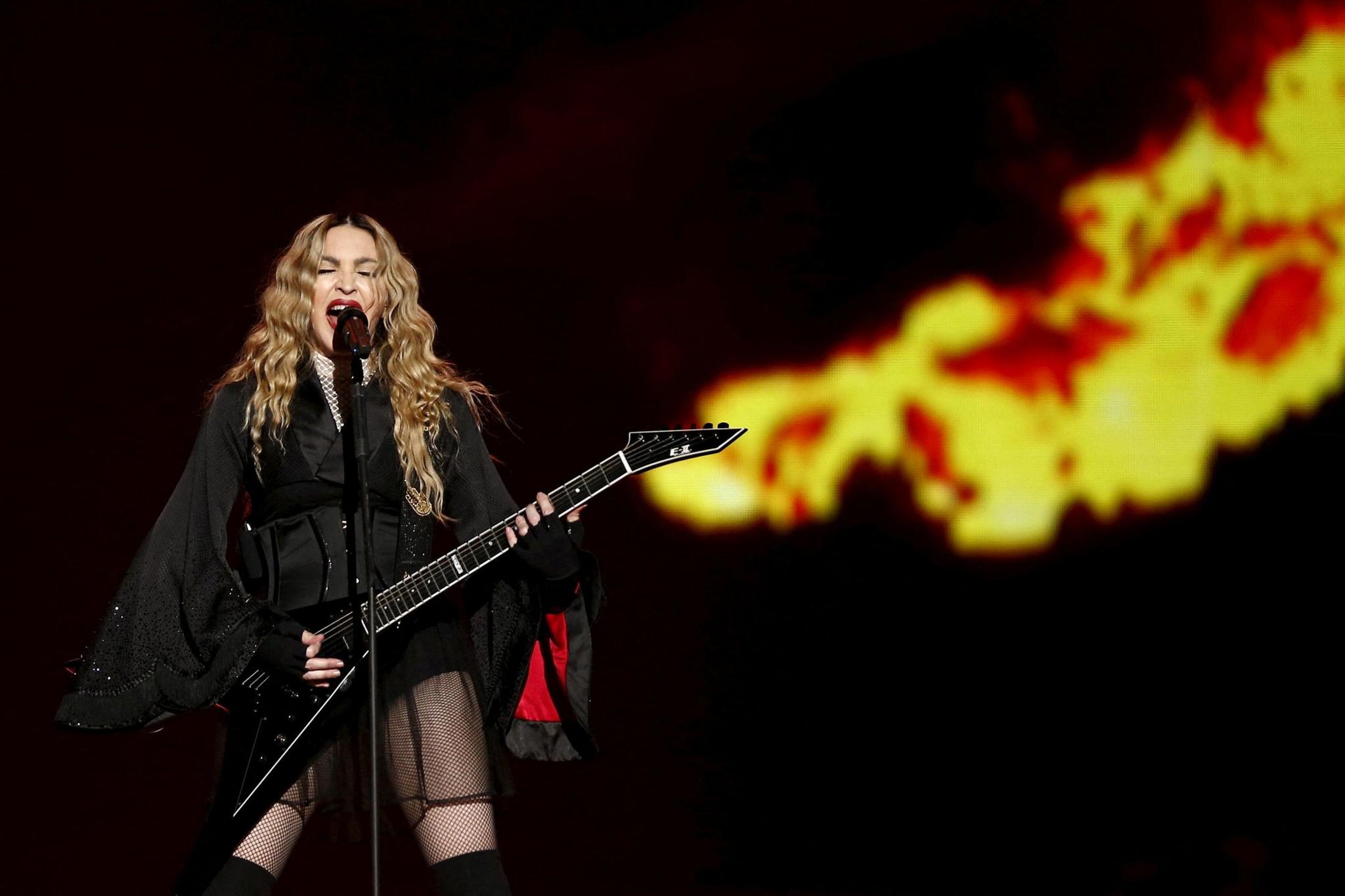 Madonna plays guitar on stage during a concert in Paris, 2023