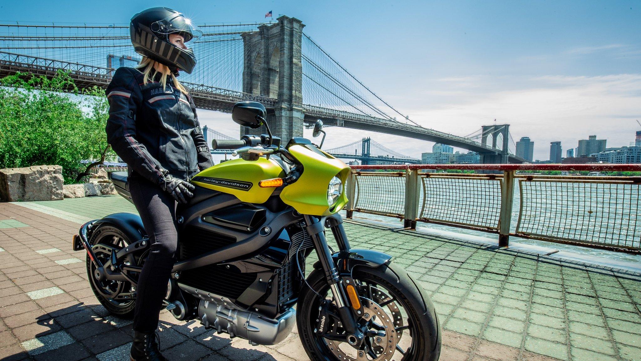 Motor bike rider looks out over river