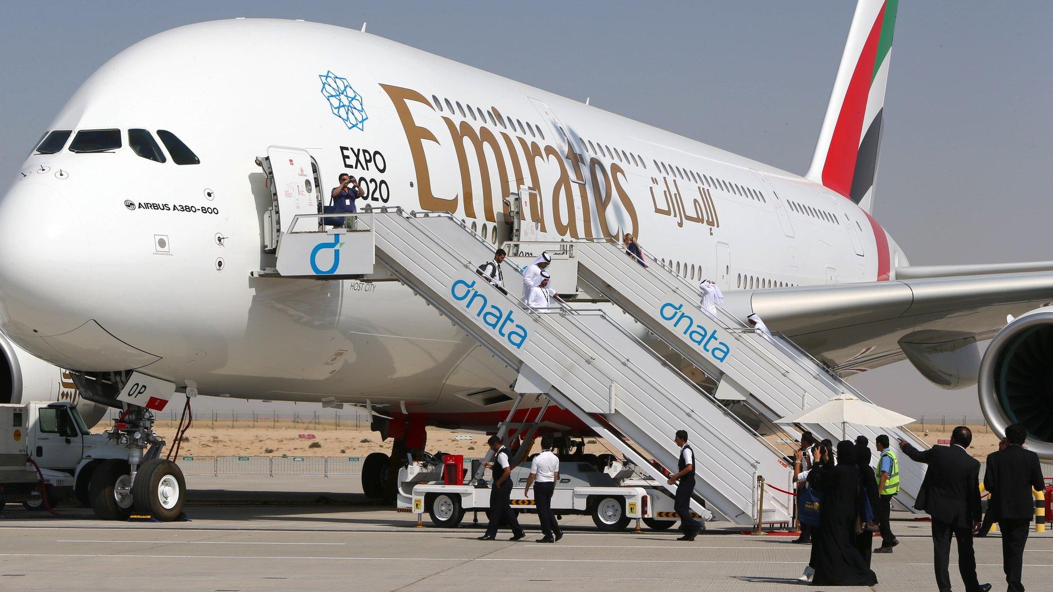 Visitors look at an Emirates airline"s Airbus A380 dislayed at the Dubai Airshow