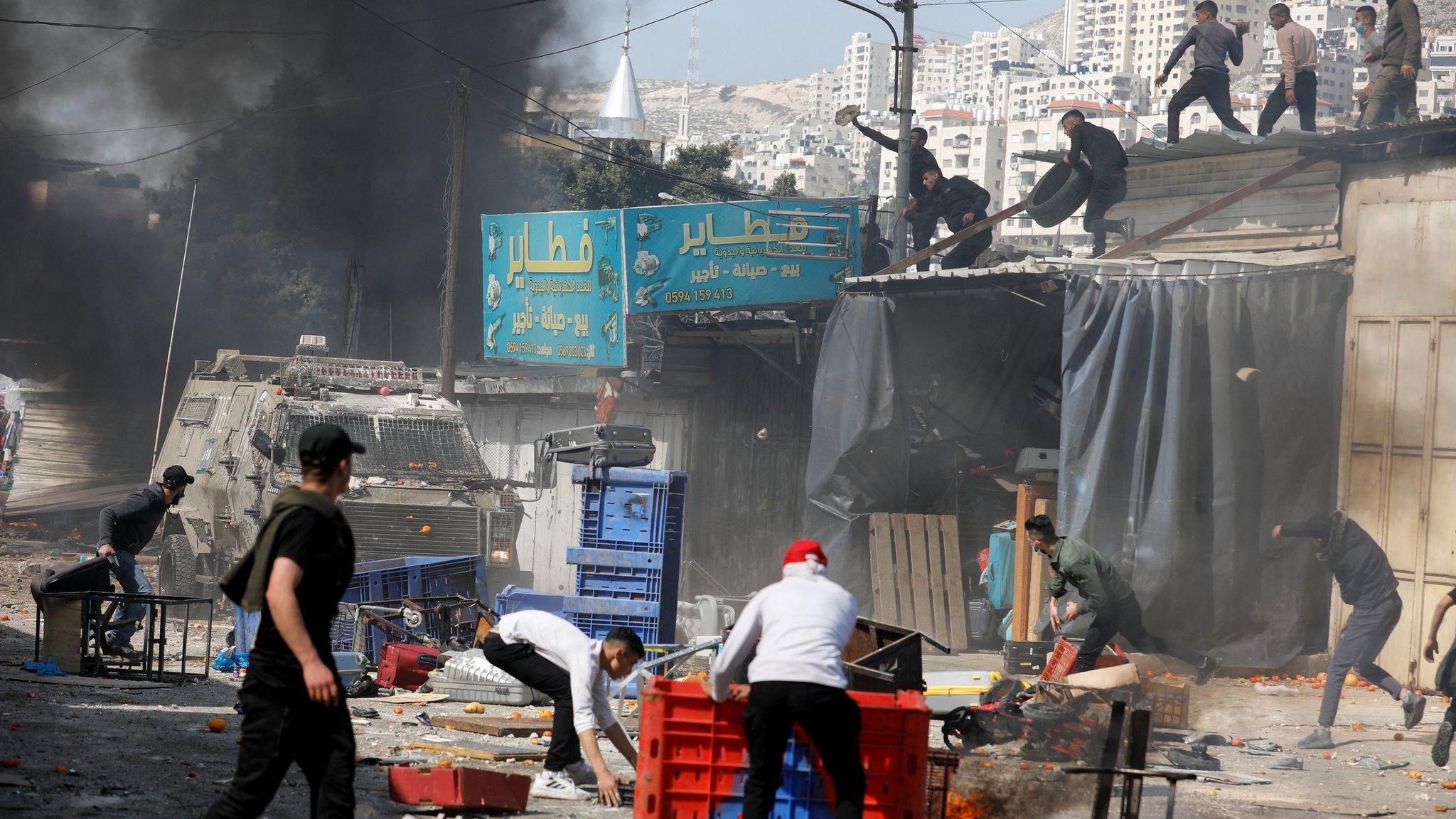 Palestinians throw objects at Israeli forces during a raid in Nablus, in the occupied West Bank, on 22 February 2023