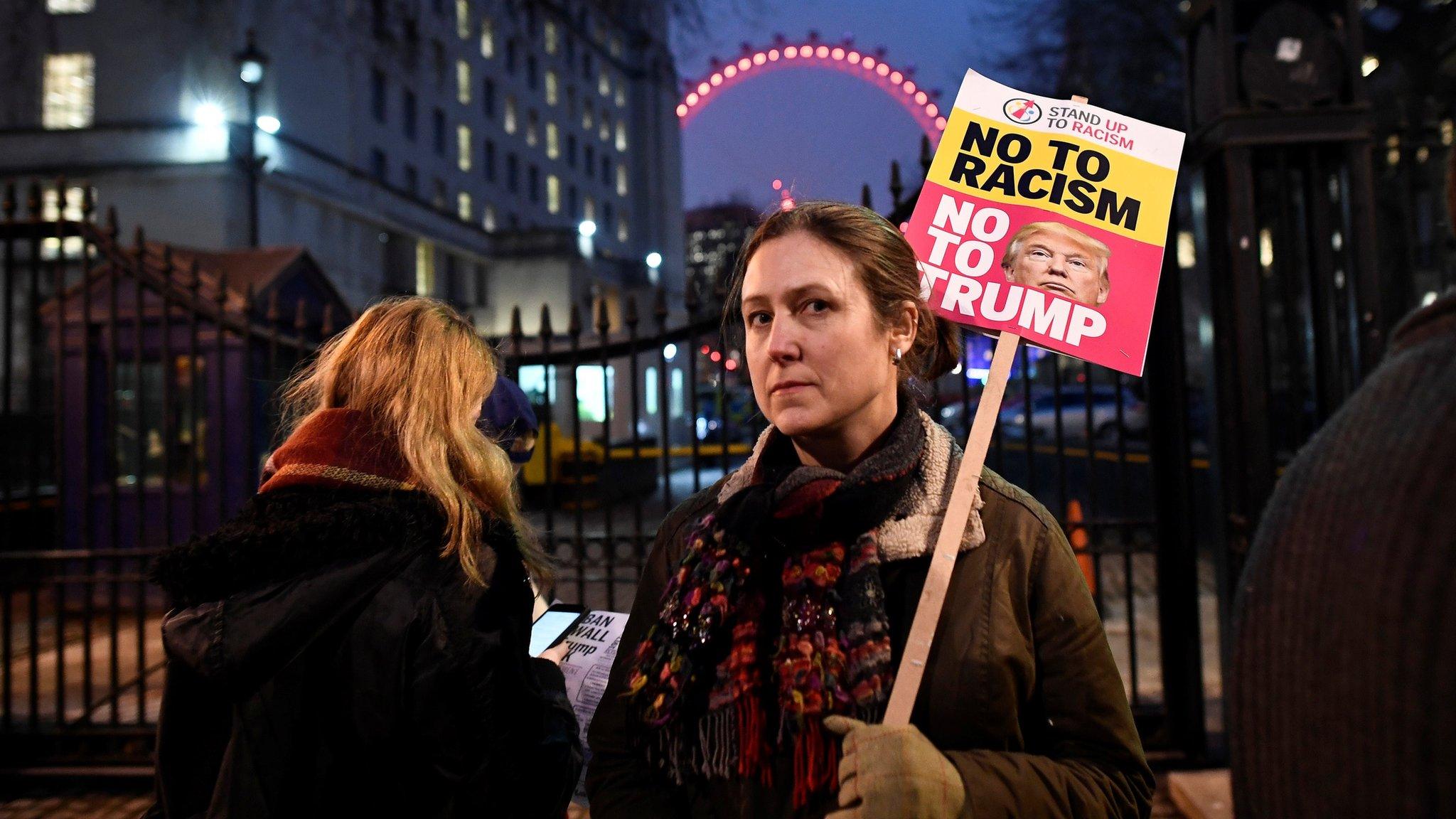 A woman holds a placard reading "no to racism, no to Trump" in central London during a protest against Donald Trump (January 30, 2017)