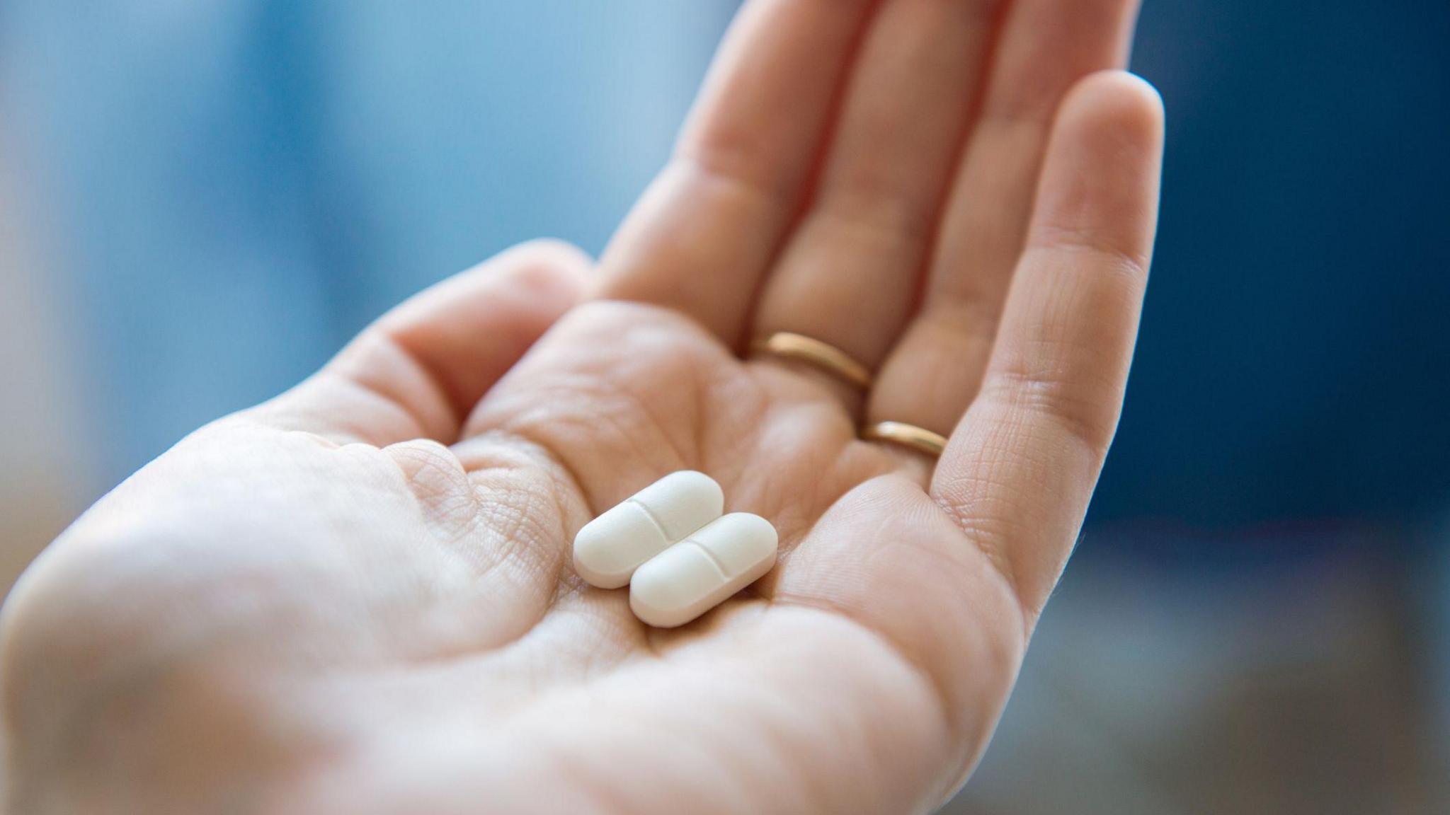 Stock image of ibuprofen in a hand