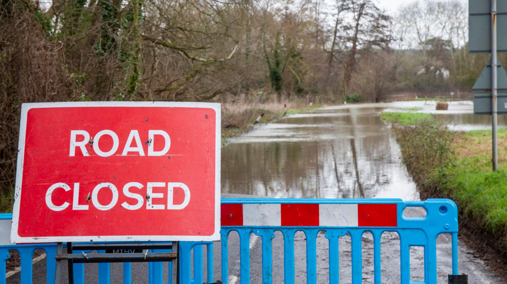 Flooded road with road closed sign.