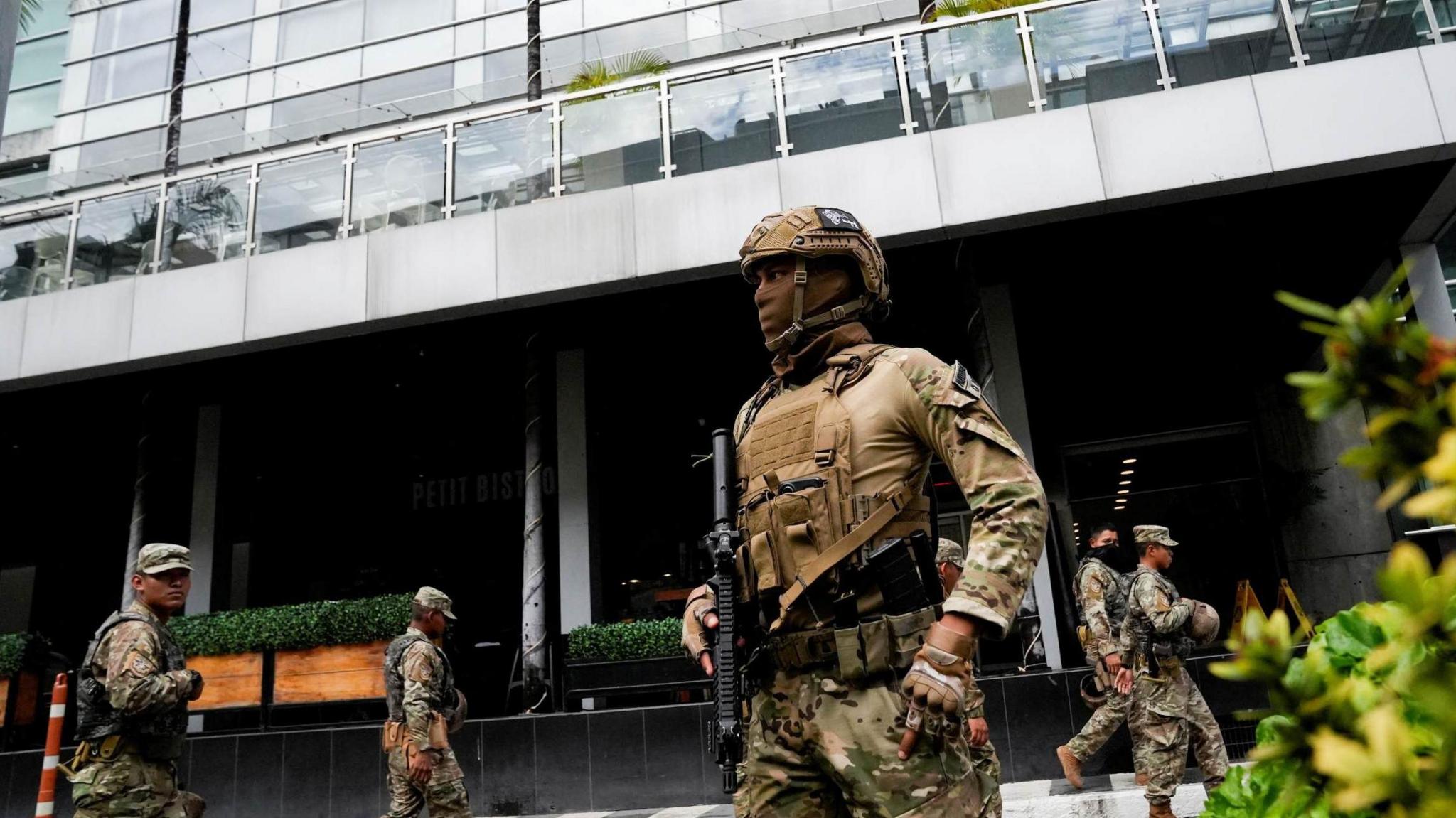 Pictures of heavily armed members of the National Aeronaval Service of Panama who are wearing masks and guarding the hotel where the deported migrants stay