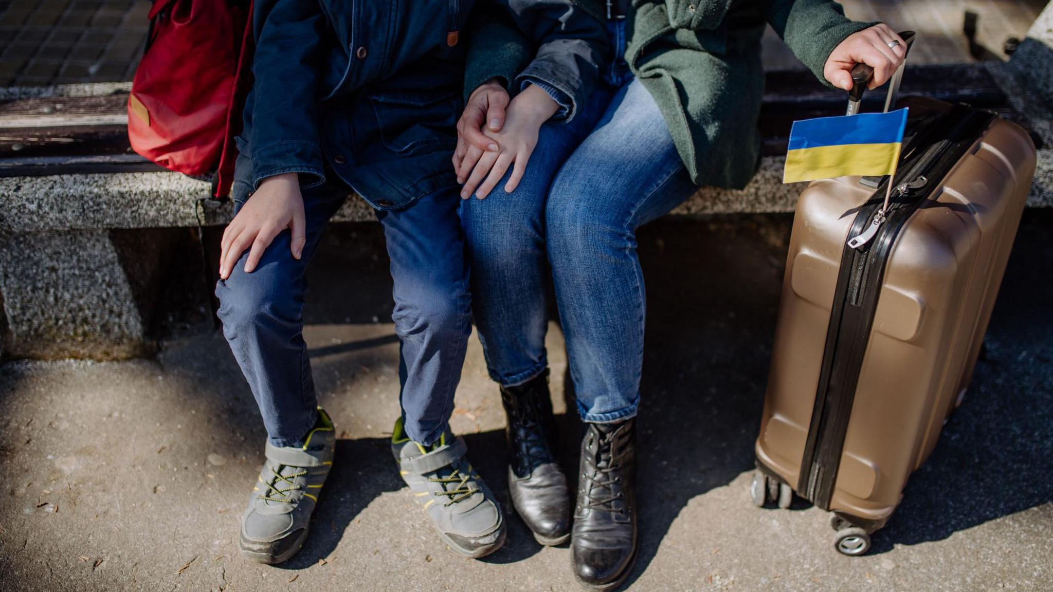 Ukrainian refugee family sitting in station when waiting to leave Ukraine due to the Russian invasion of Ukraine