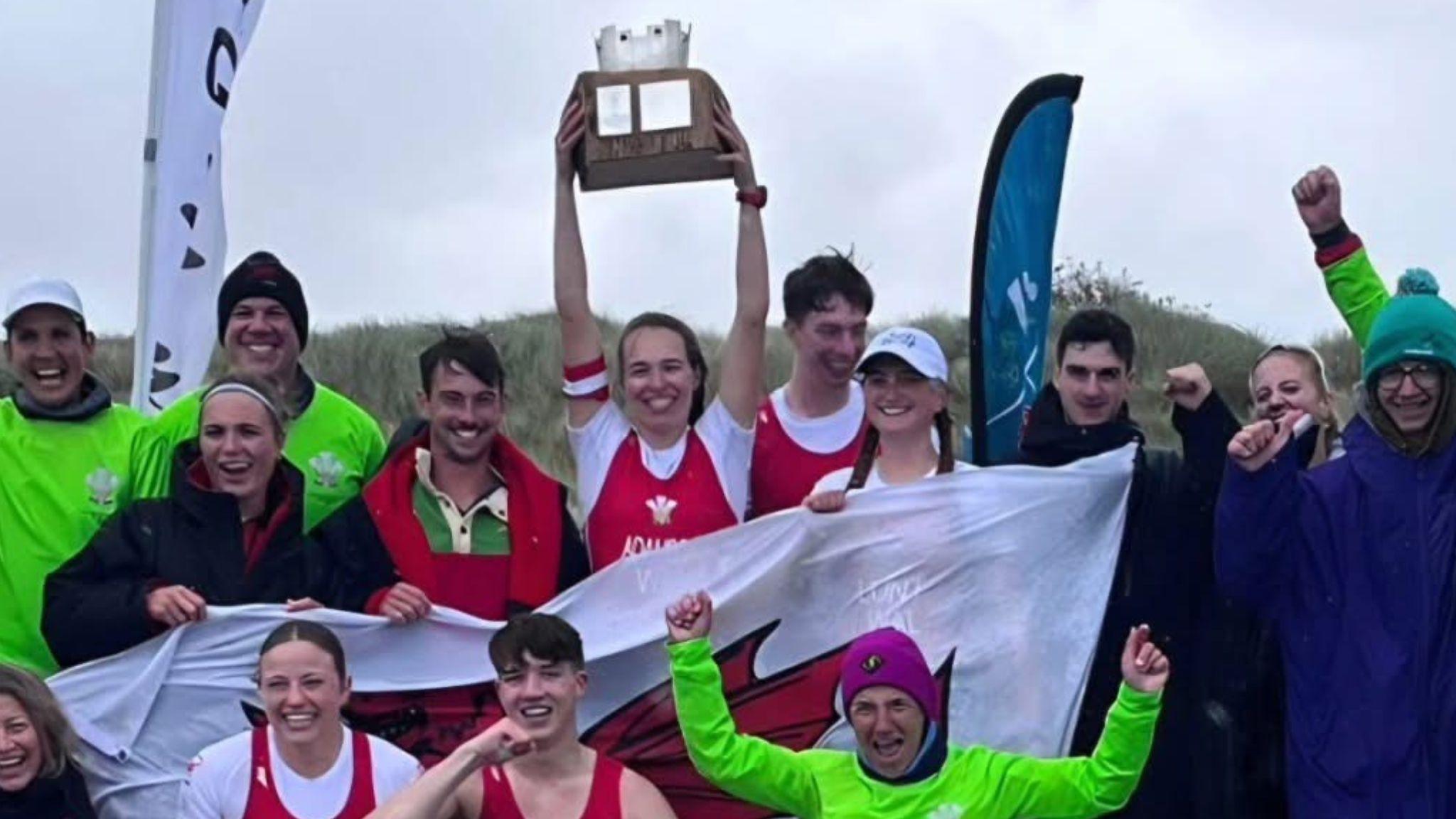 Members of the Wales team celebrate holding a Welsh flag and the Home International Rowing Beach Sprint Championships trophy