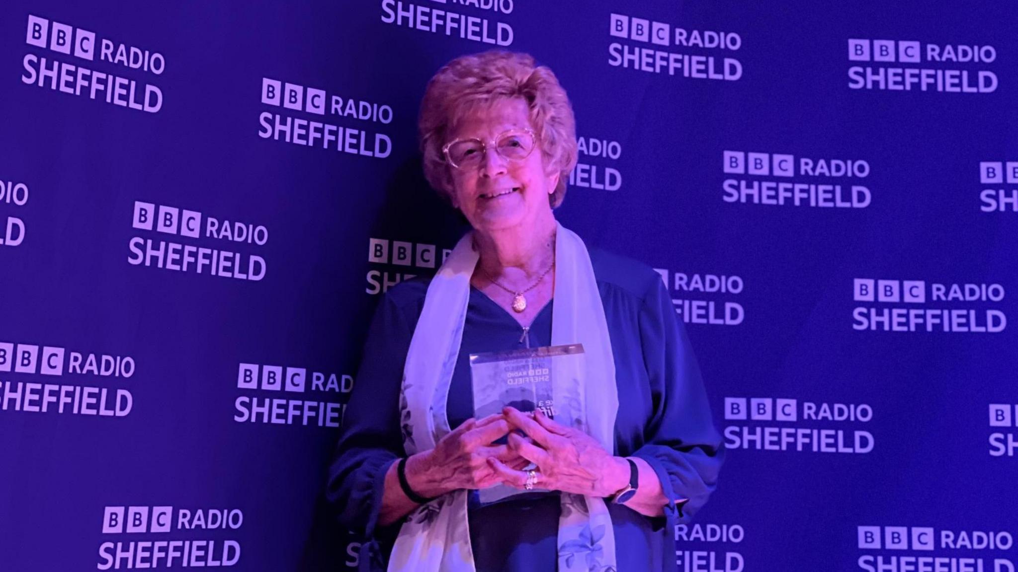 A woman holding an award