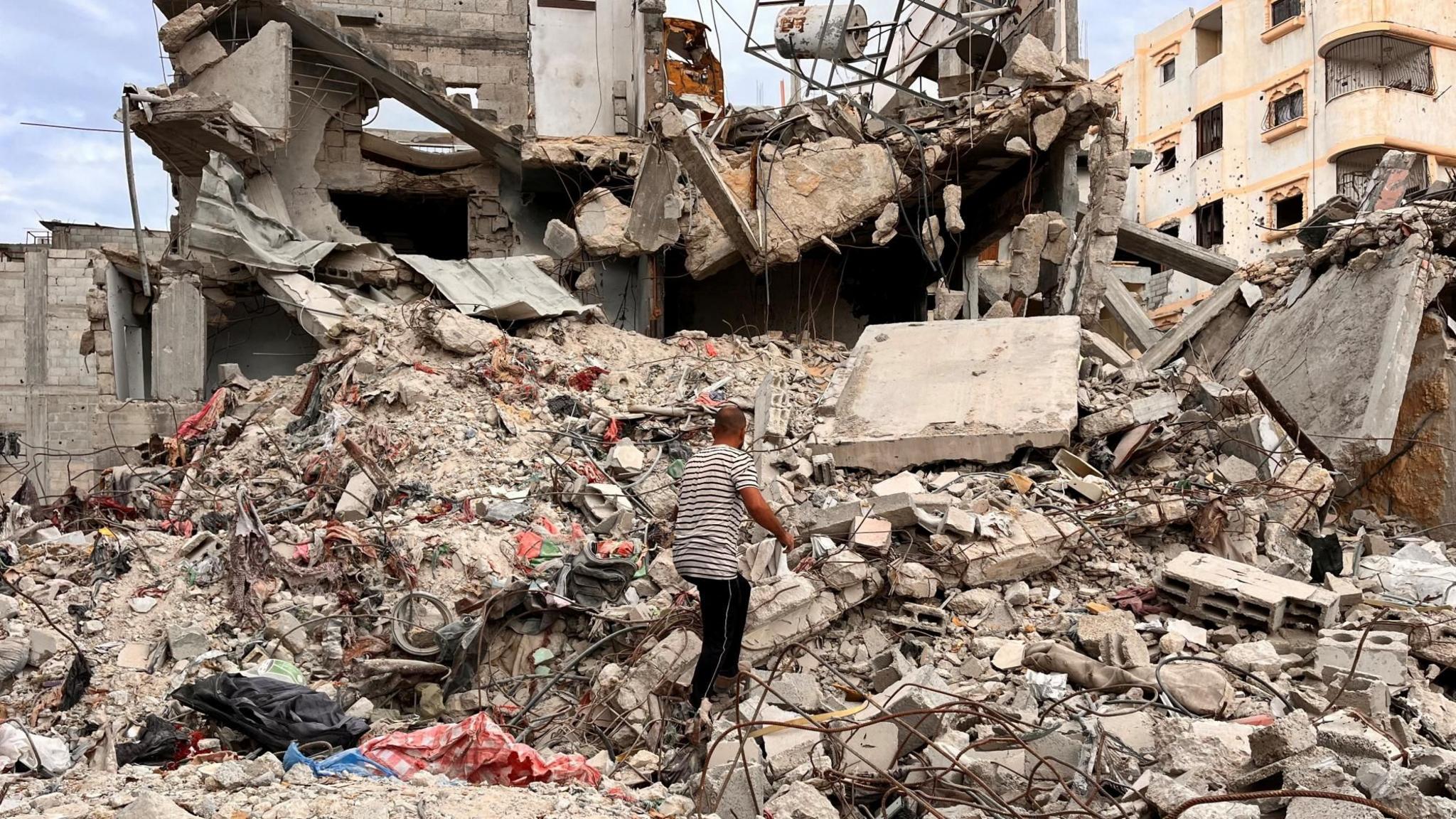 A man searches through the rubble of a house in Khan Younis in the Gaza Strip