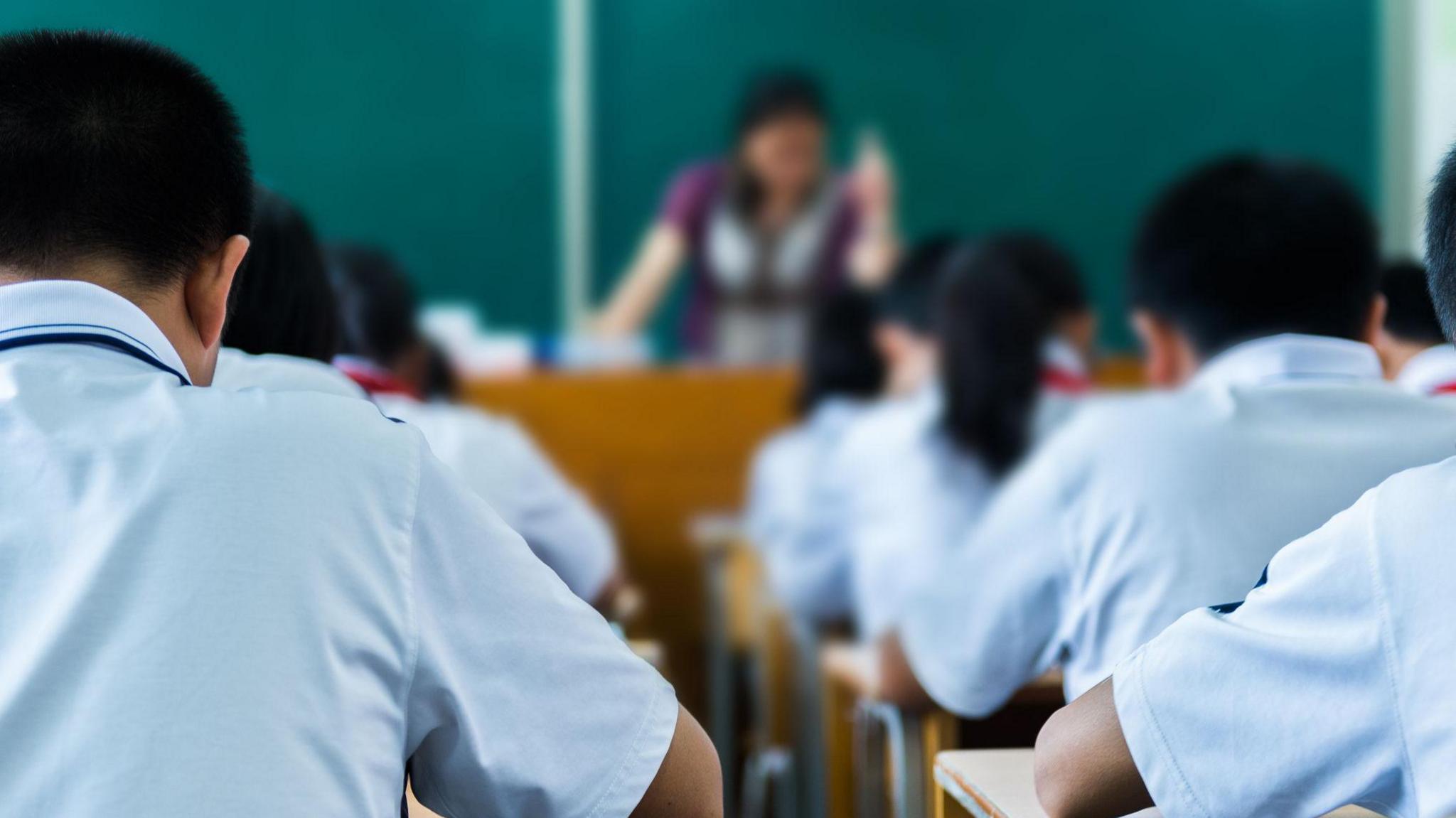 Back view of students studying in a classroom