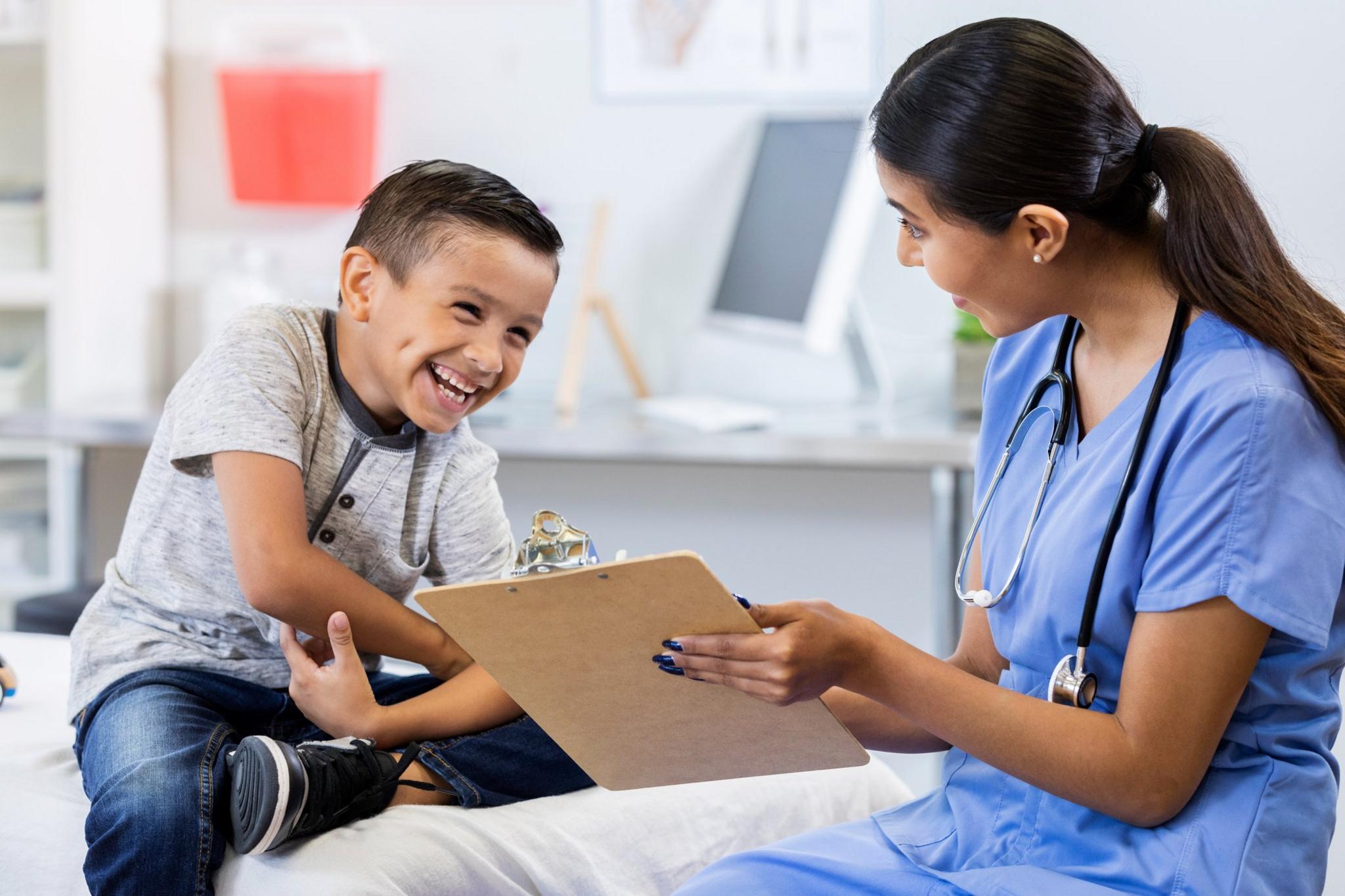 young-boy-laughing-while-talking-to-doctor