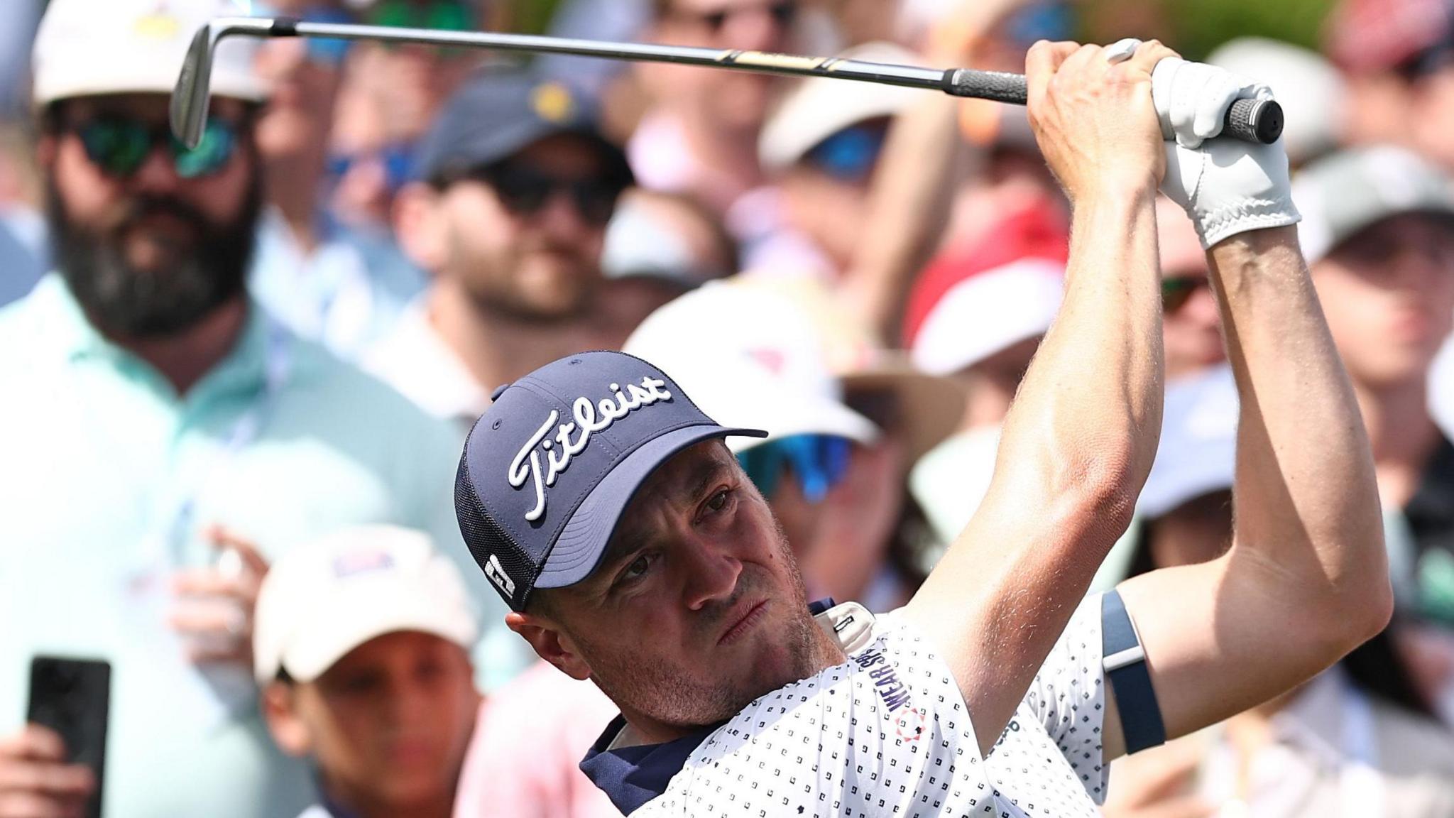 Justin Thomas watches an iron shot 