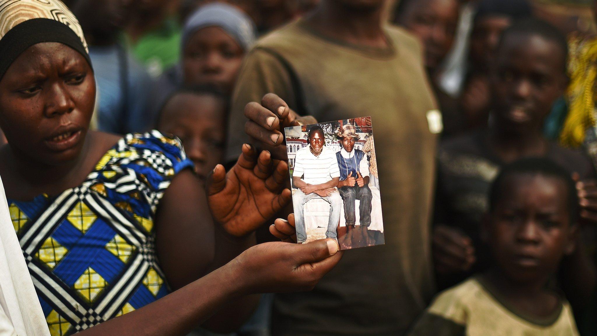 A woman holds up a picture of someone killed by the security forces in Bujumbura in July 2015