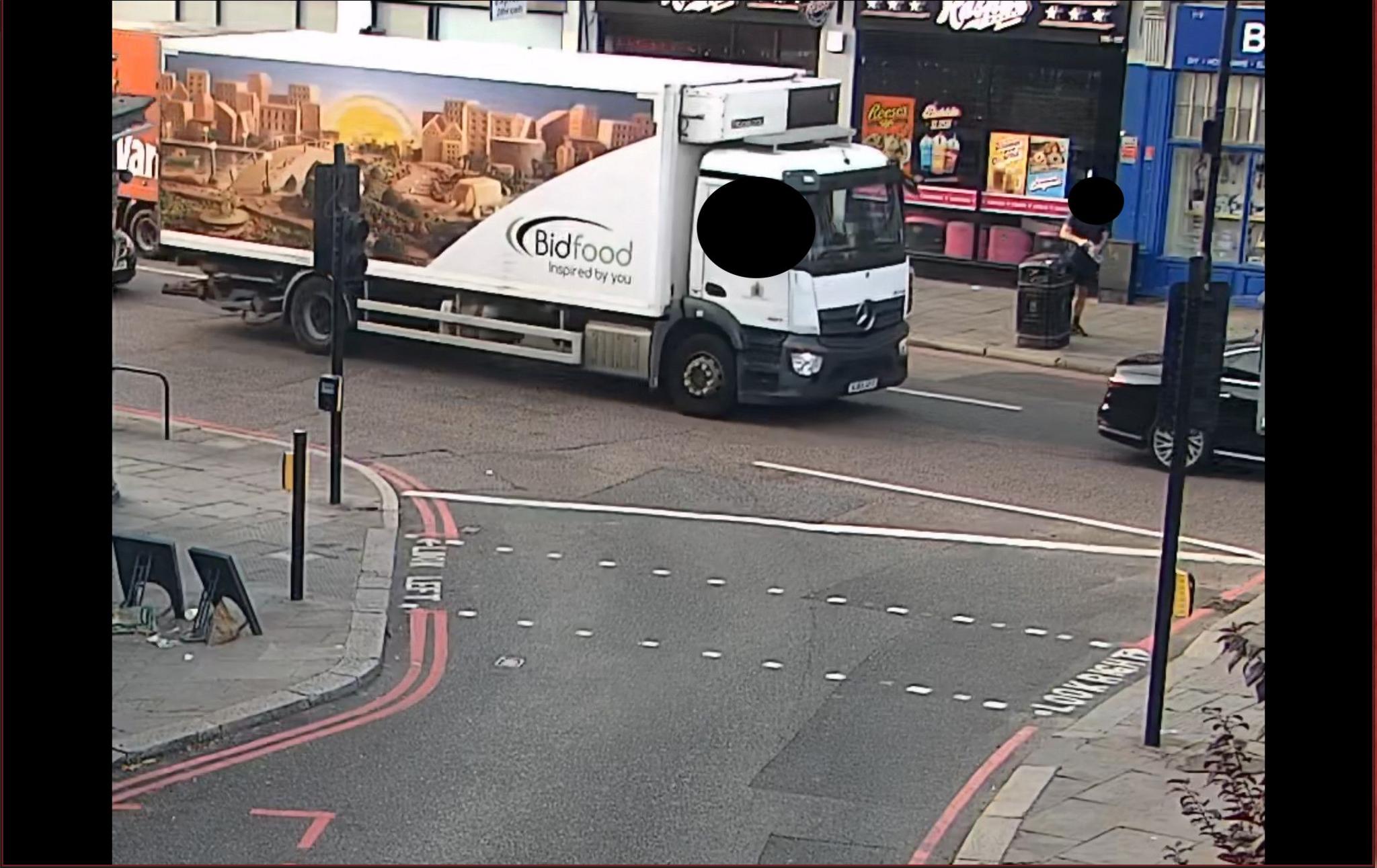 A large white Bidfood lorry is seen driving on a high street in CCTV images shared by the Met Police