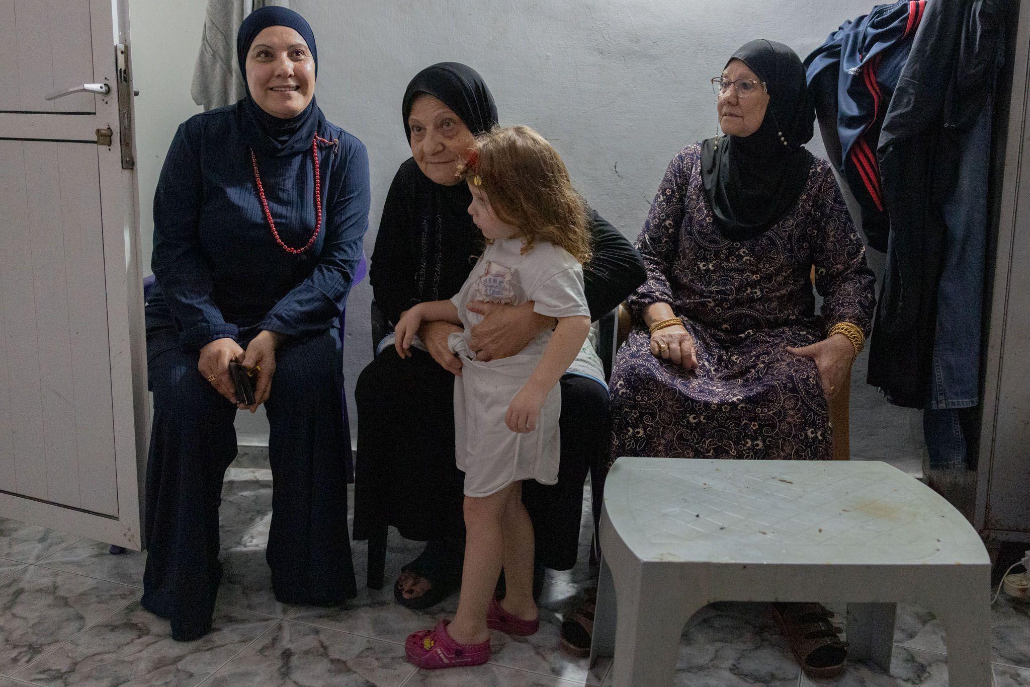 Three women and a young girl sit inside a safe room.