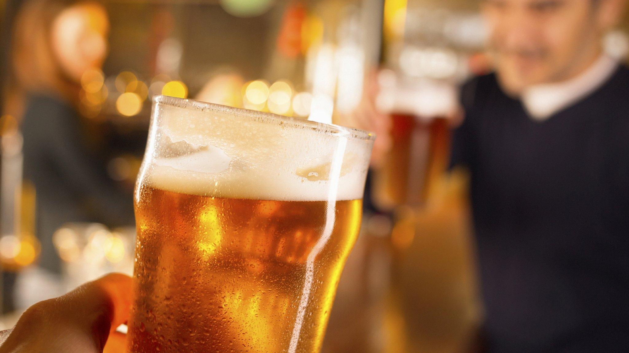 Glass of beer (with pub in blurry background)