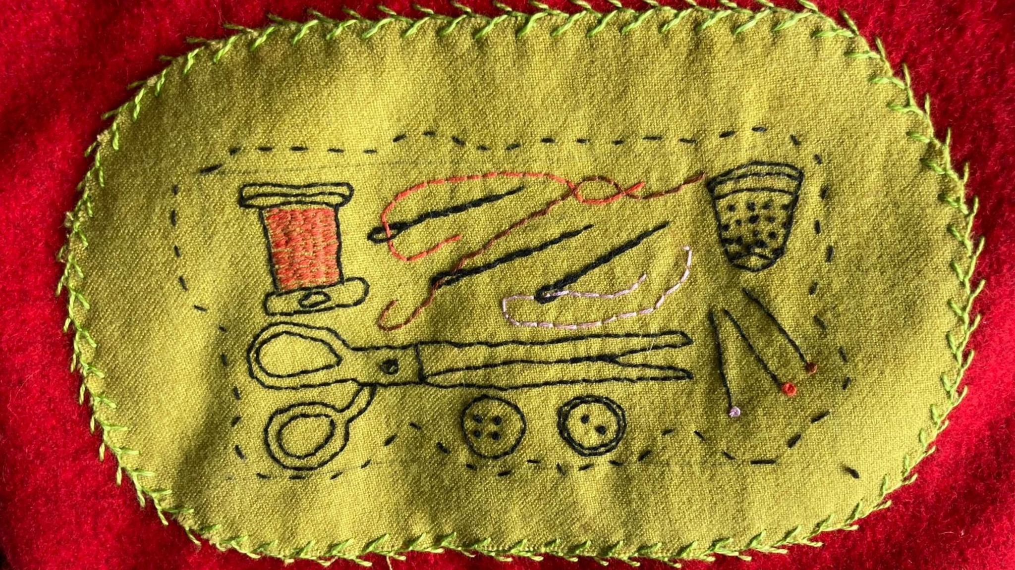 one of the patches of the coat representing a needle and thread 