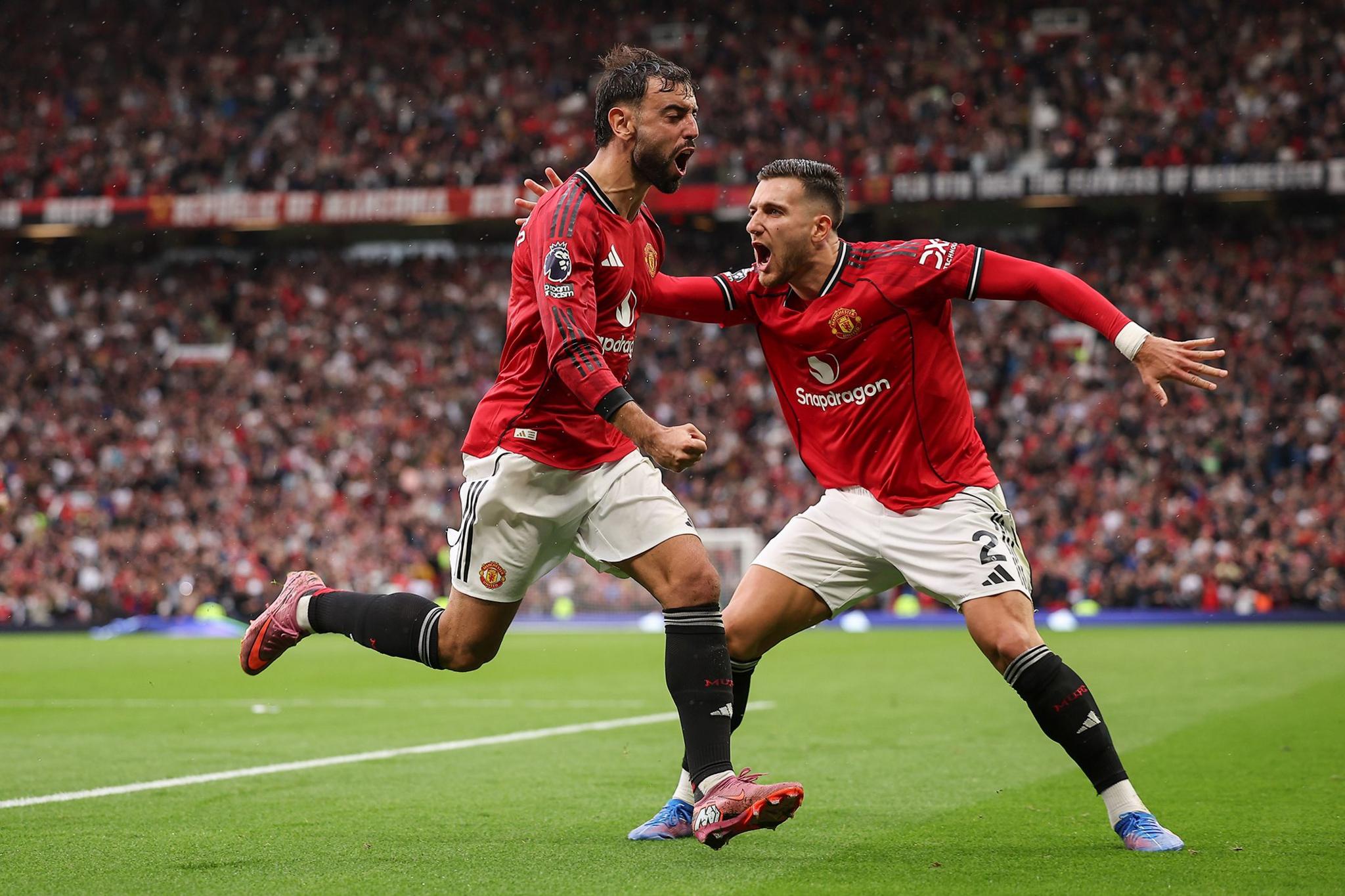 Manchester United's Bruno Fernandes celebrates with Diogo Dalot after scoring their third goal to make the score 3-2 at Old Trafford. Photo by Daniel Chesterton