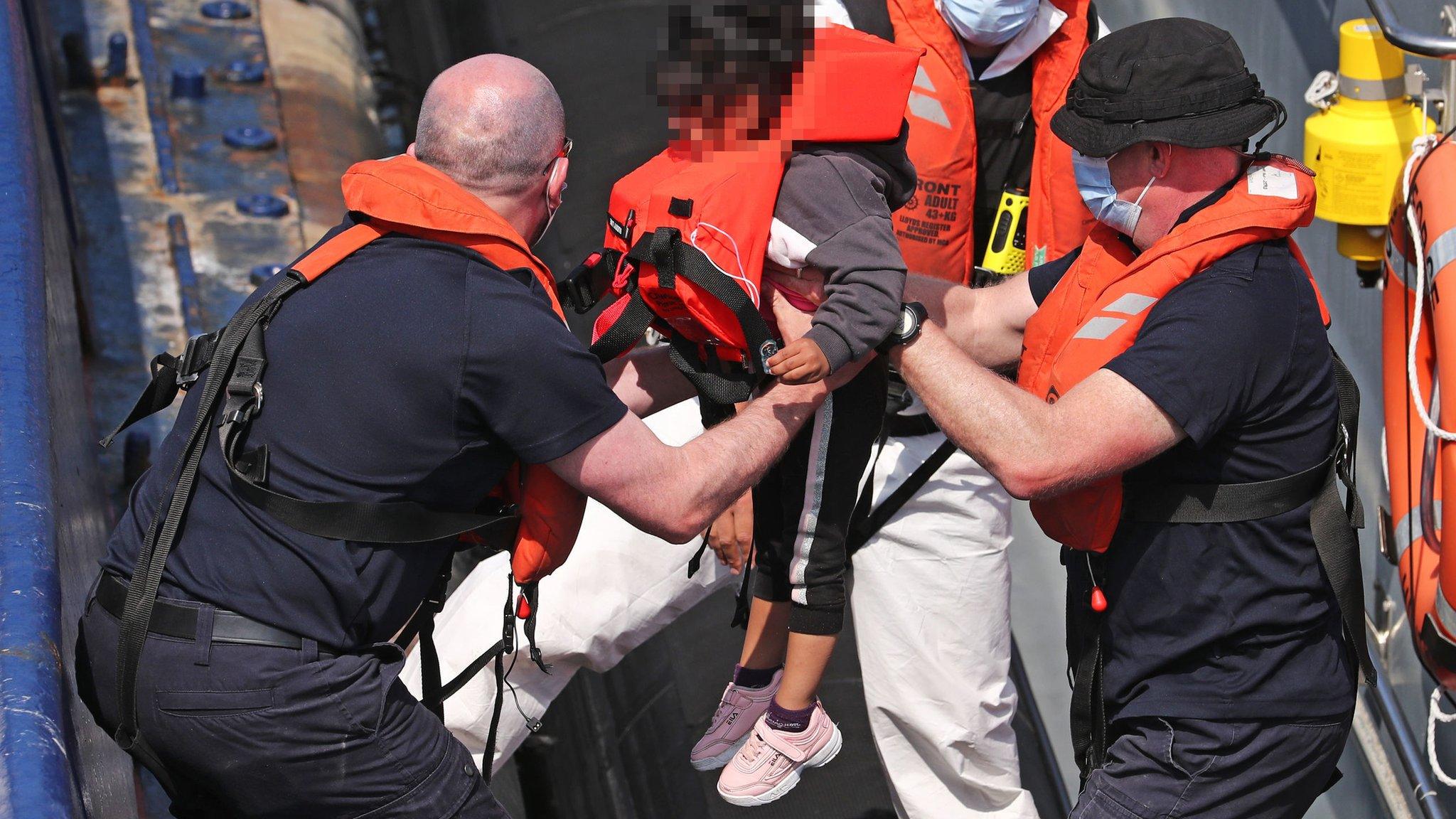 A group of migrants, including children, are brought to Dover