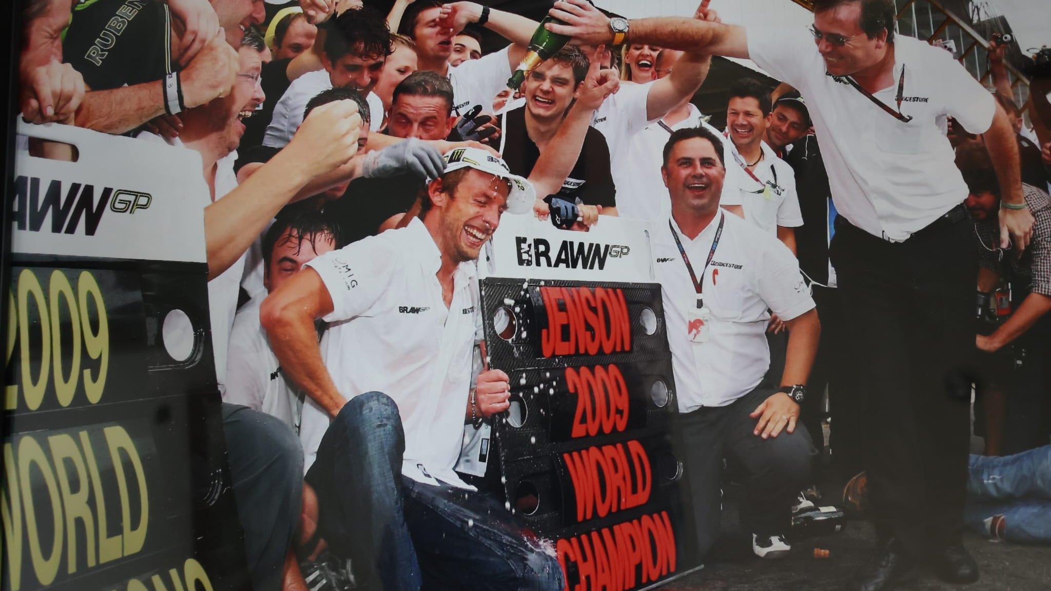 Dave Freeman pours champagne over Jenson Button