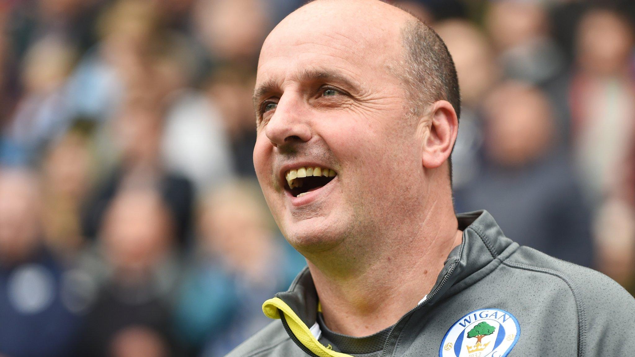 Paul Cook smiles from the touchline