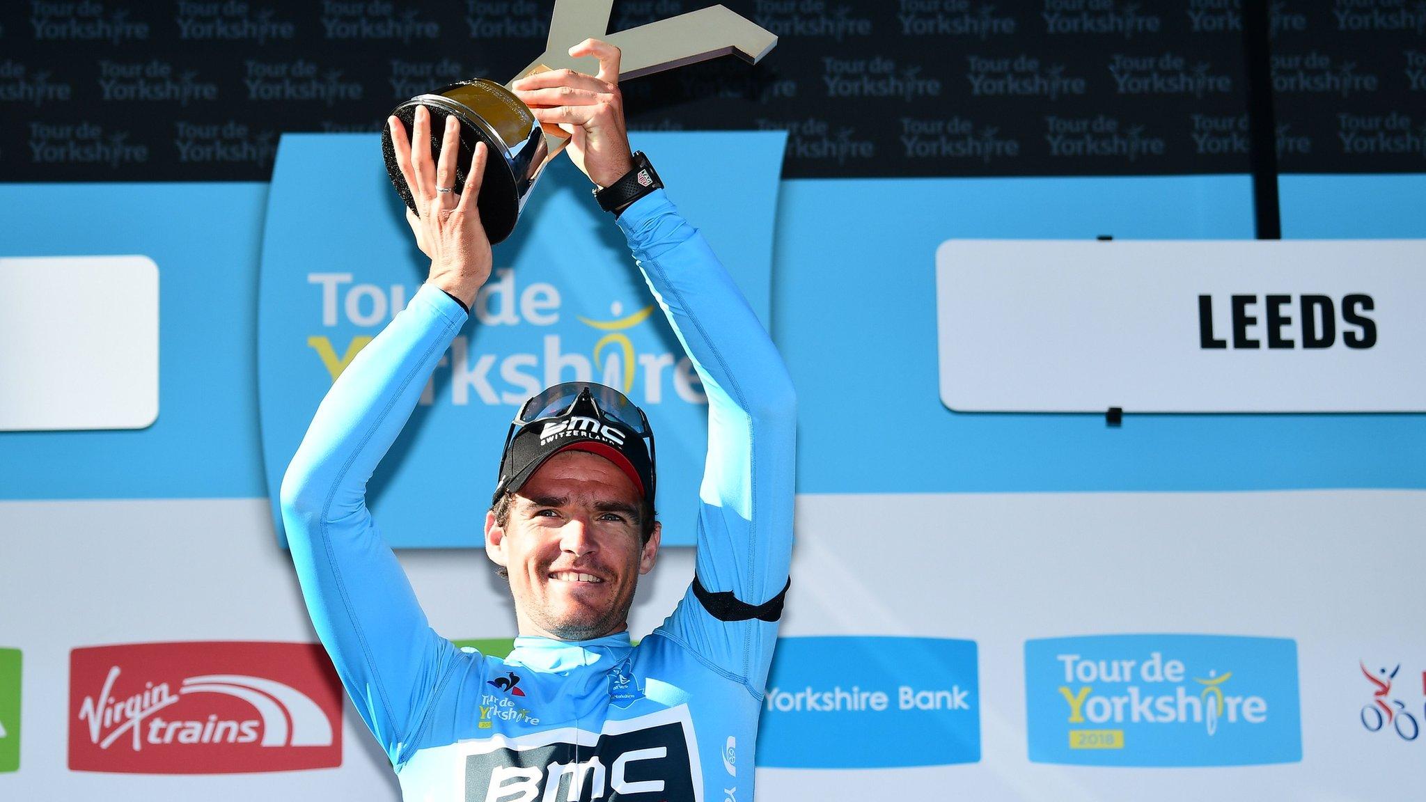 Greg van Avermaent holds up a Y shaped gold trophy to celebrate winning the 2018 Tour de Yorkshire