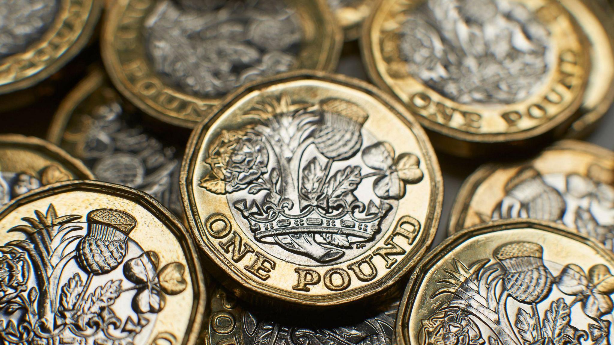 A stock image of gold and silver pound coins. 