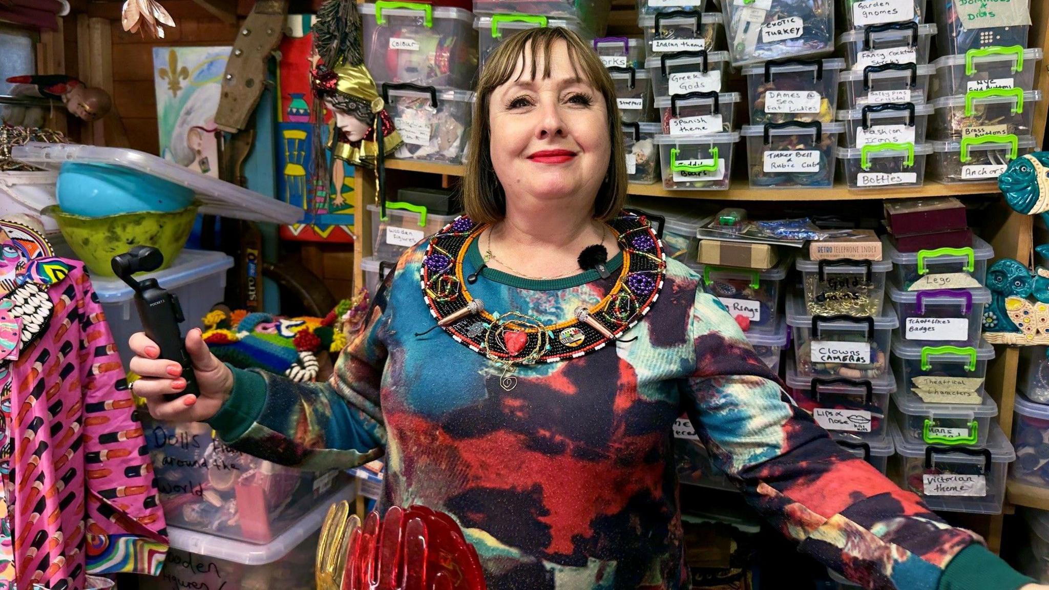 A middle-aged woman in a colourful dress wearing a decorated east African beaded collar