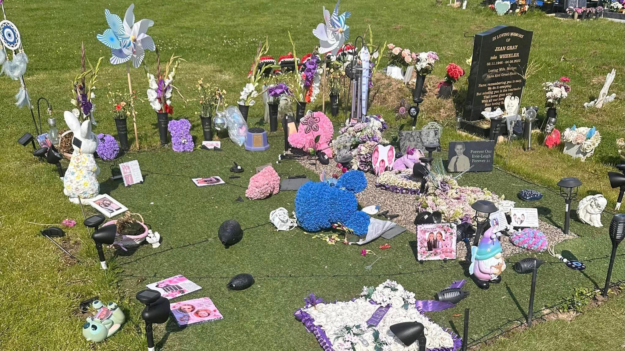 Broken solar lights and torn teddy bears lying across Evie Leigh's grave.