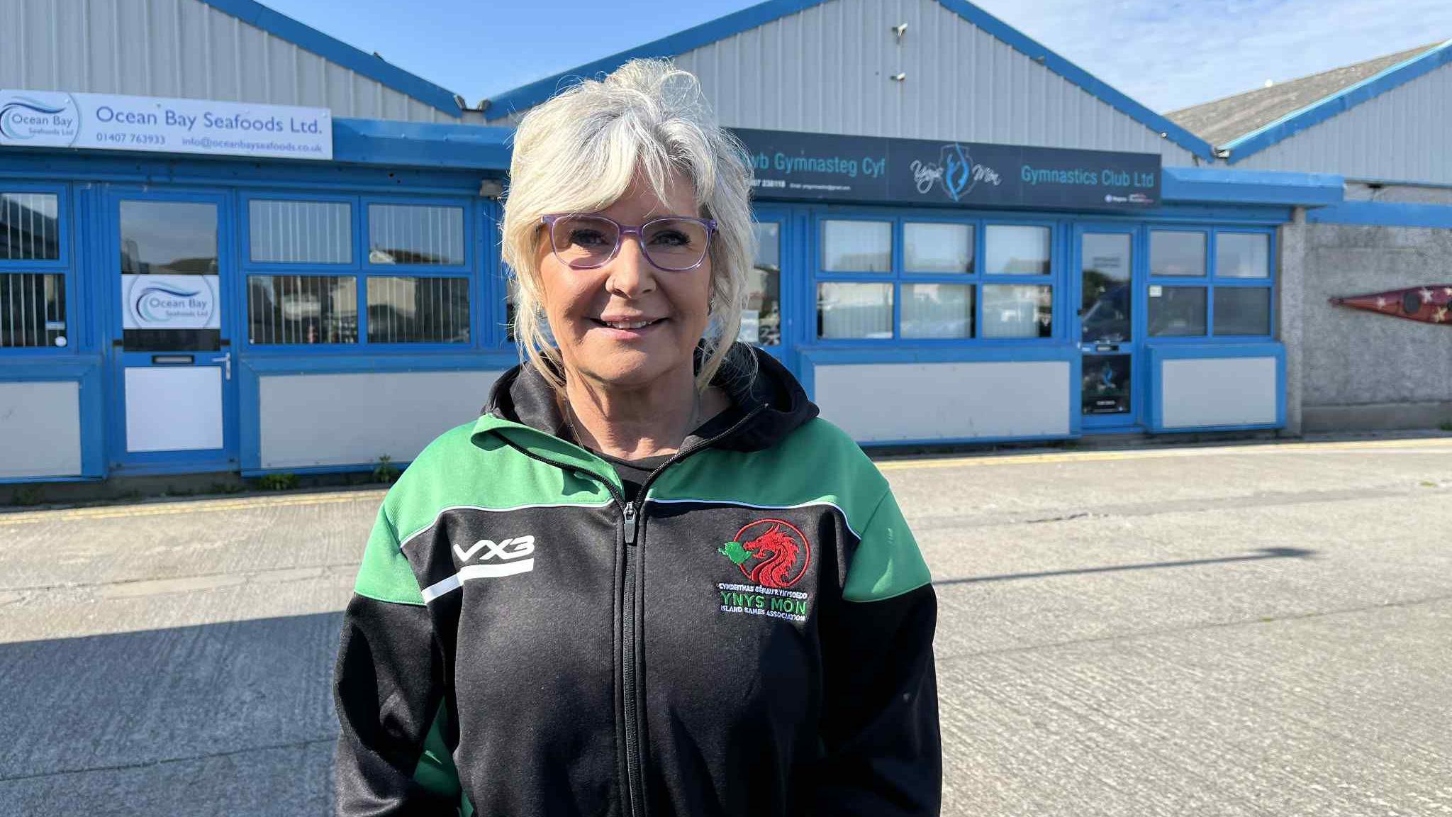 Catherine Rowley in an Island Games jacket outside of Ynys Mon Gymnastics Club.