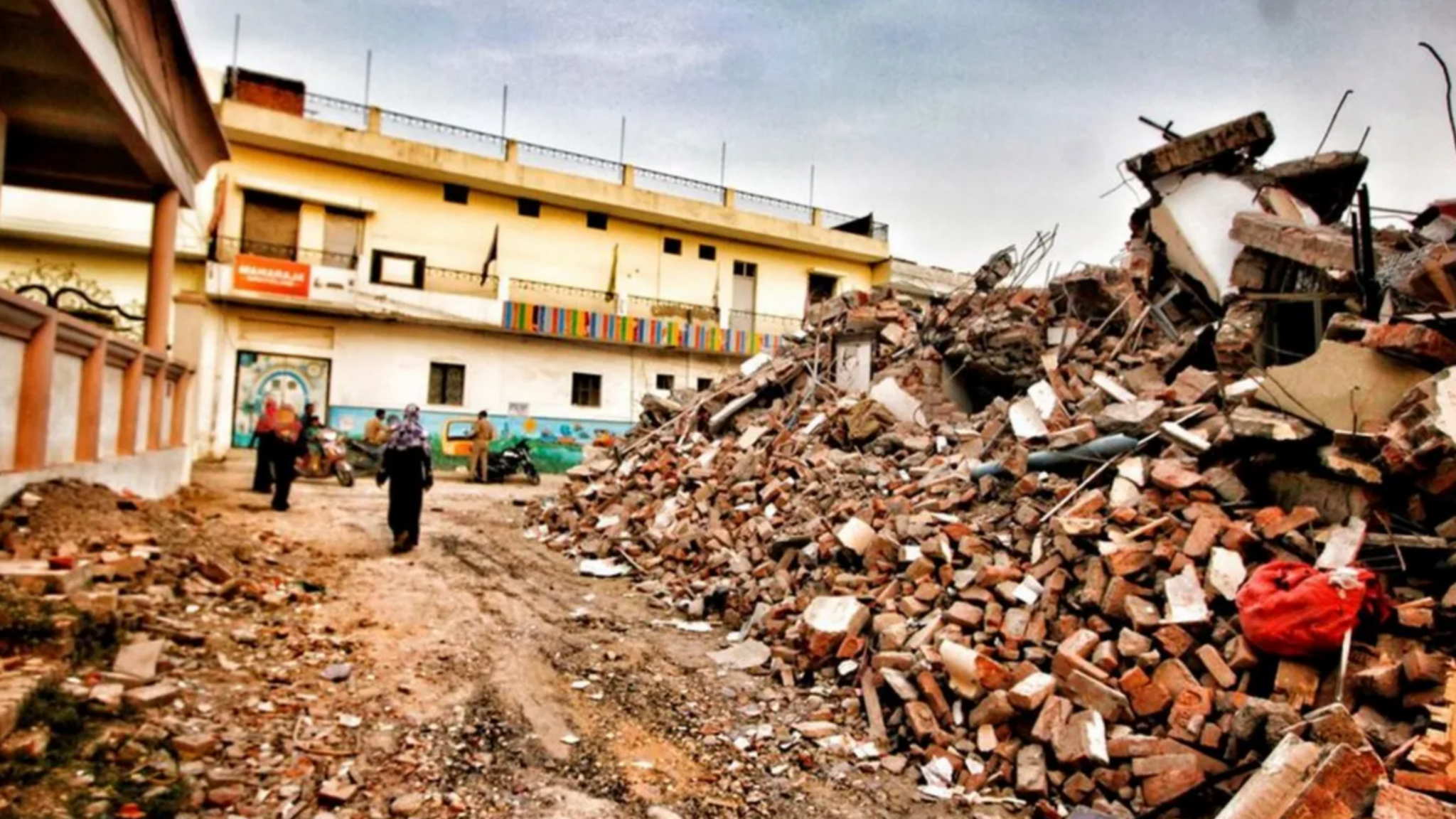 People standing outside Javed Mohammad's home in India's Uttar Pradesh state after it was demolished