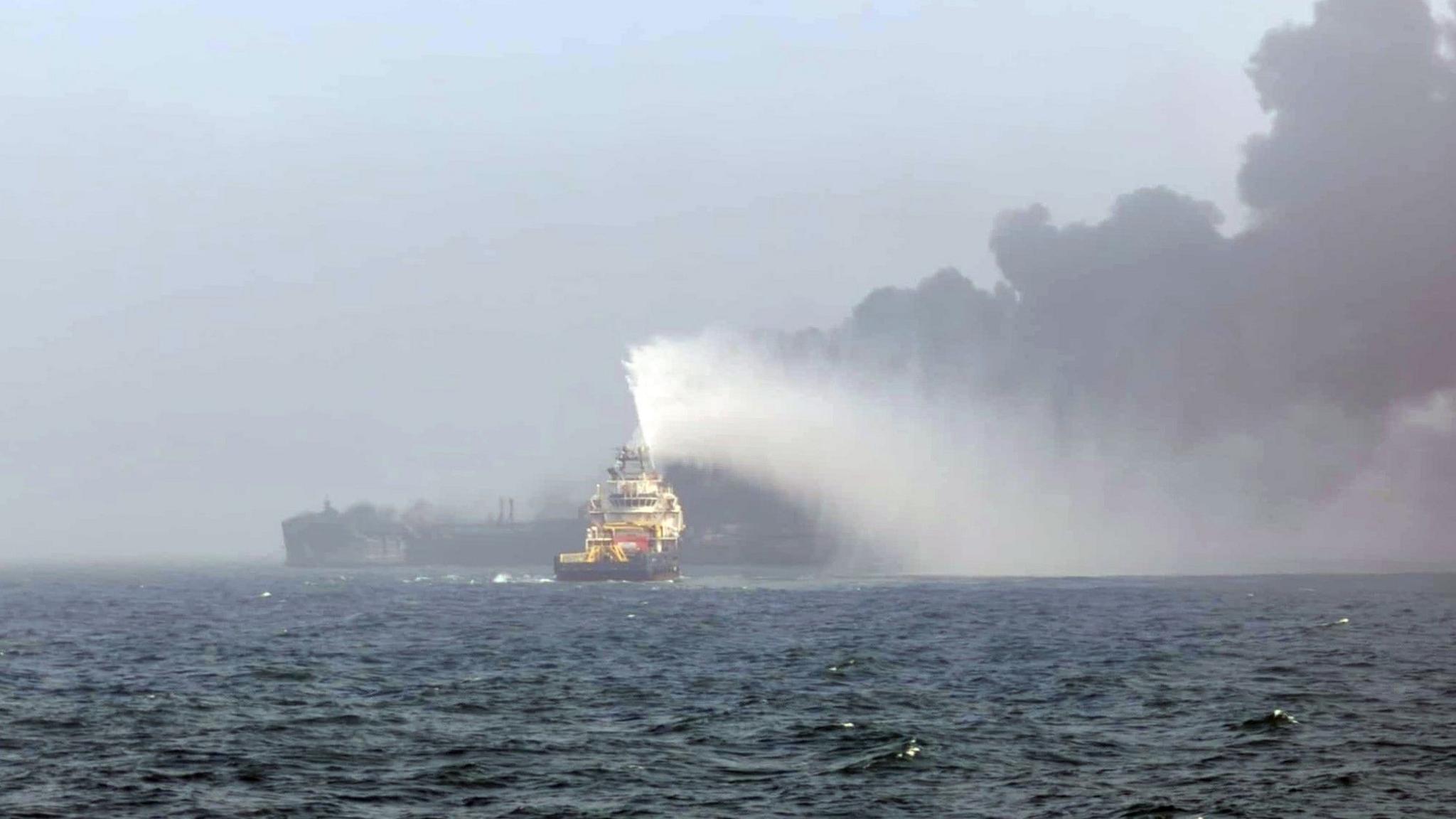 A lifeboat heading towards the site of the crash in the North Sea with a black cloud of smoke bilowing above one of the vessels.