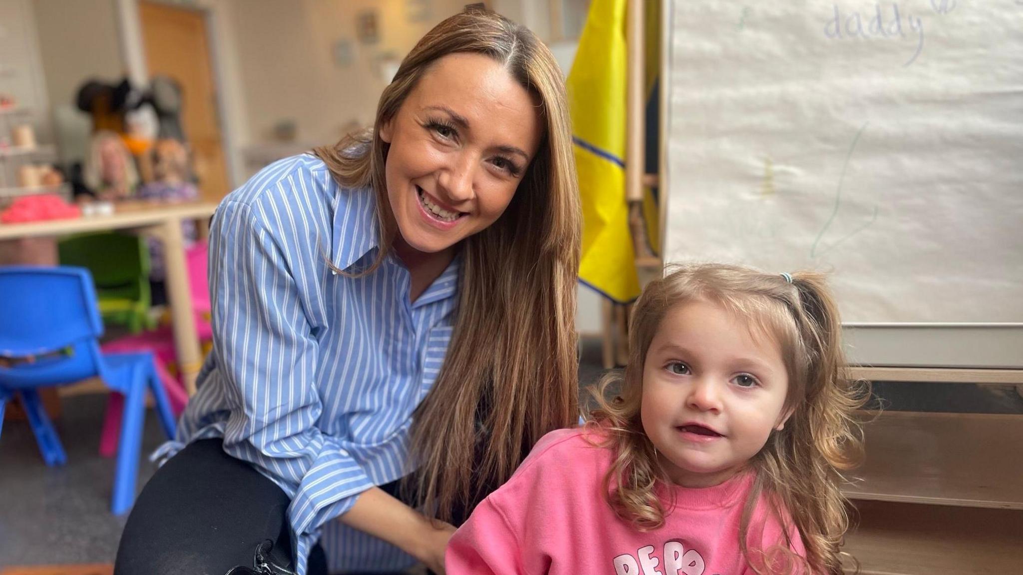 Stephanie Thomas and her daughter looking at the camera