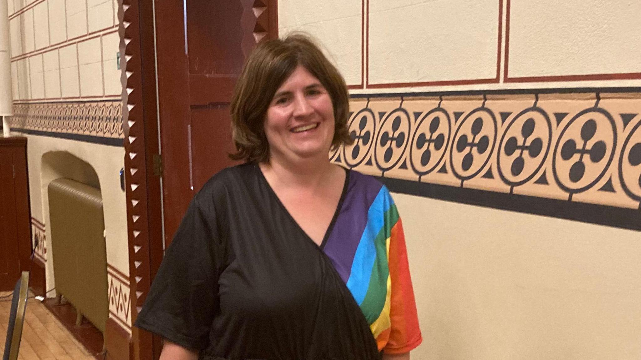 Councillor Zoe Smith in a black dress with a rainbow pattern.