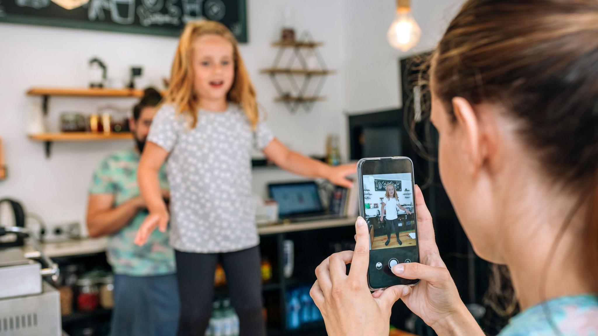 Mum recording daughter dancing